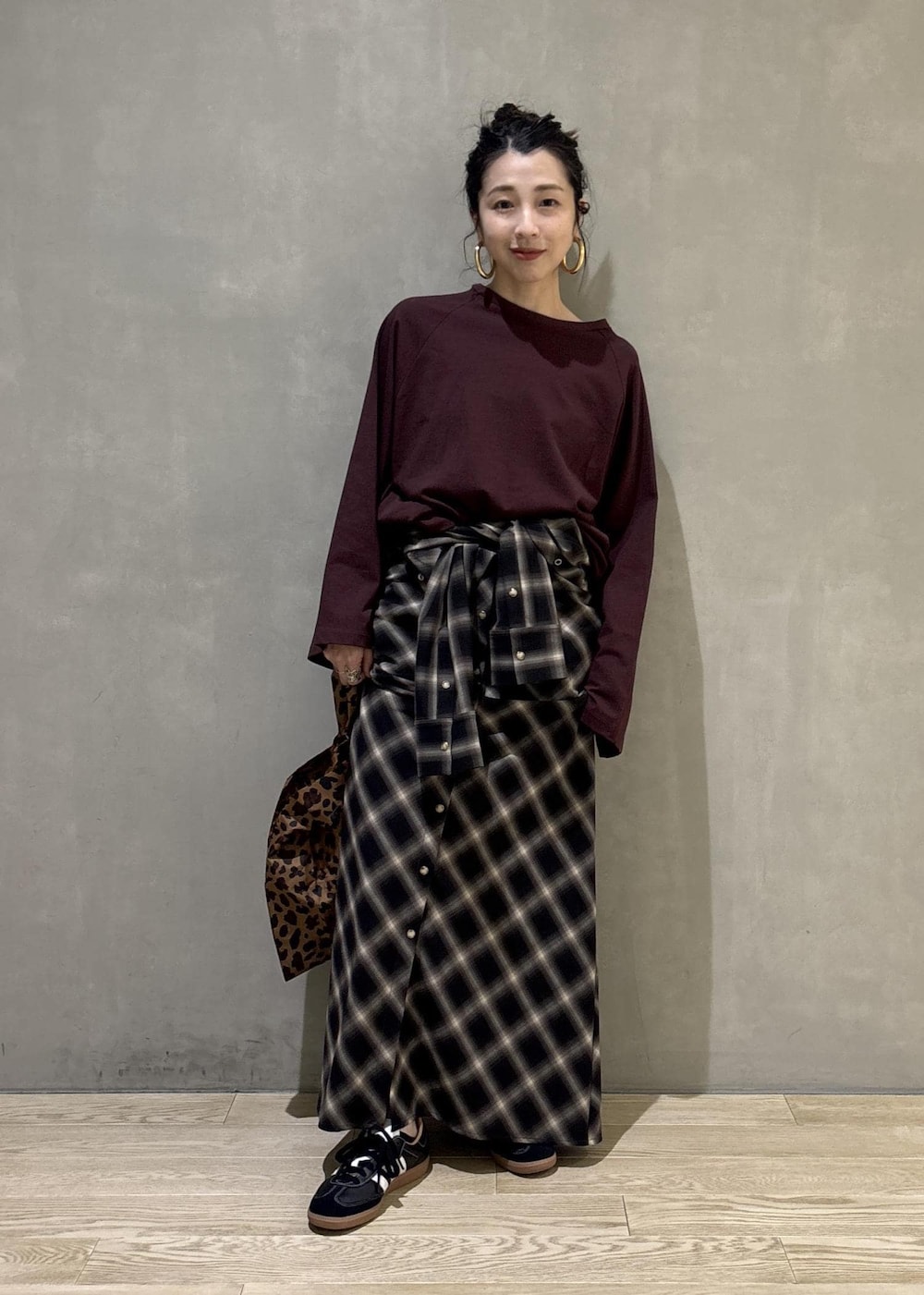 ブラック系のスニーカーを着用したレディースの秋コーディネートの2枚目の写真