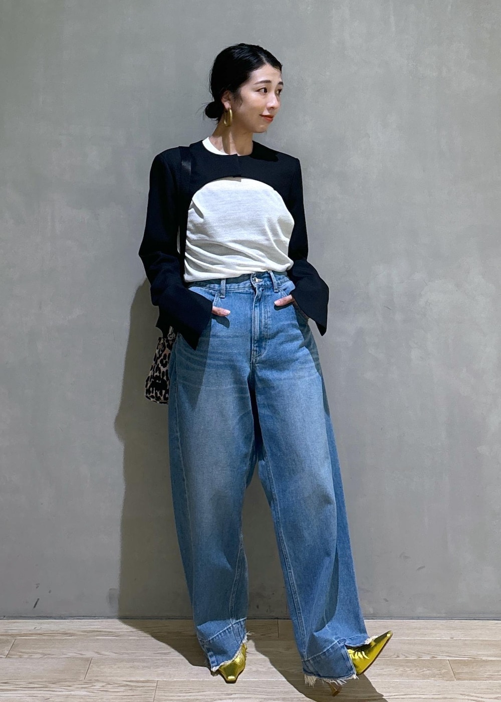 ブルー系のデニムパンツ、ゴールド系のパンプス、ブラック系のノーカラージャケットを着用したレディースの秋コーディネートの6枚目の写真