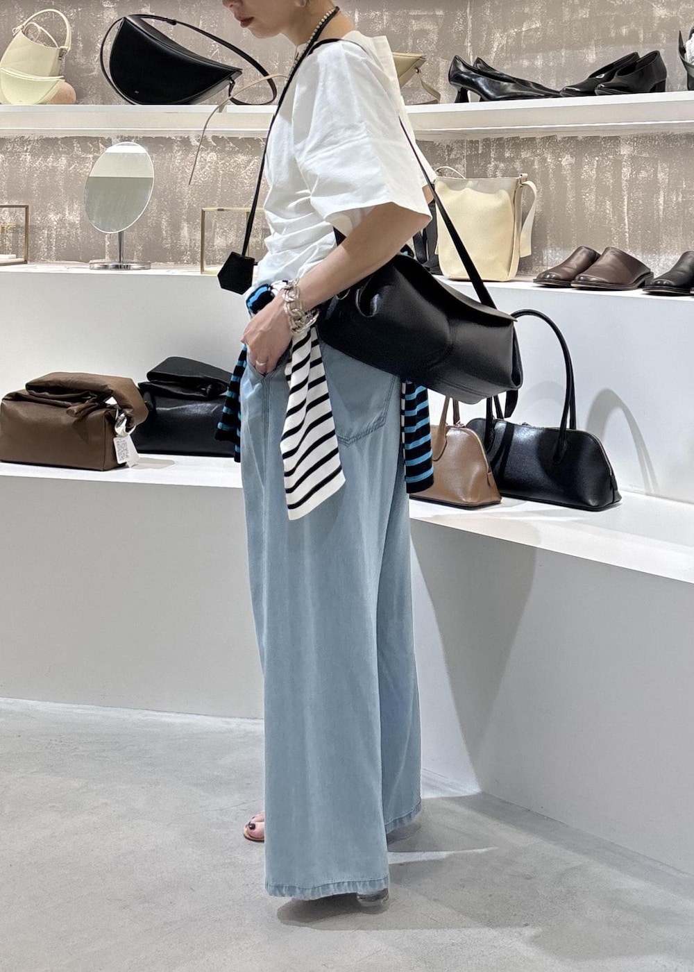 ブルー系のデニムパンツ、ブラック系のショルダーバッグ、ブルー系のTシャツ/カットソーを着用したレディースの春コーディネートの8枚目の写真