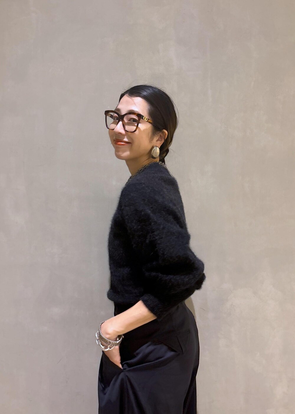 ホワイト系のパンプス、ブラック系のスラックス、グレー系のニット/セーターを着用したレディースの秋コーディネートの9枚目の写真