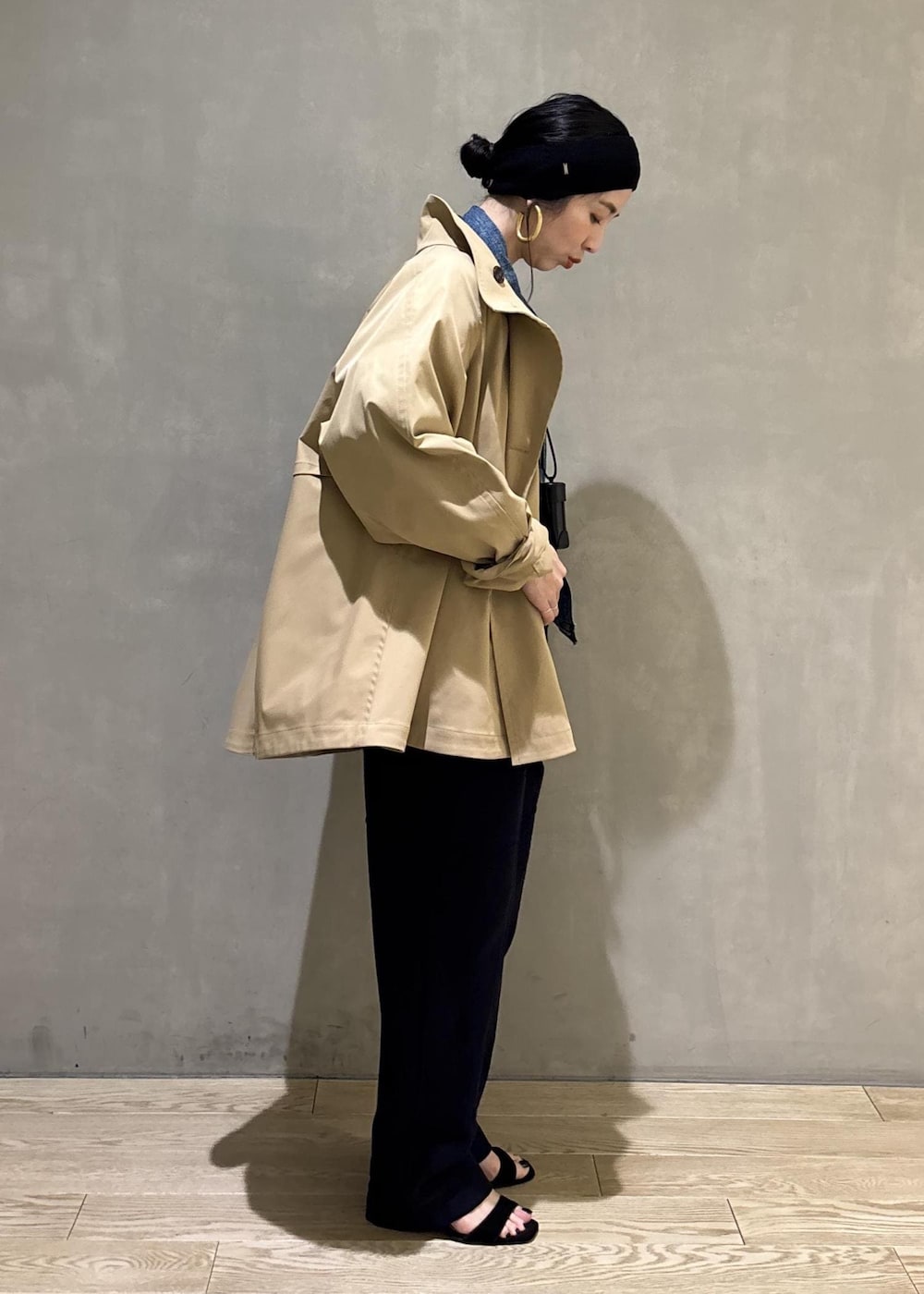 ベージュ系のトレンチコート、ブルー系のデニムジャケット、ブルー系のその他パンツを着用したレディースの春コーディネートの4枚目の写真