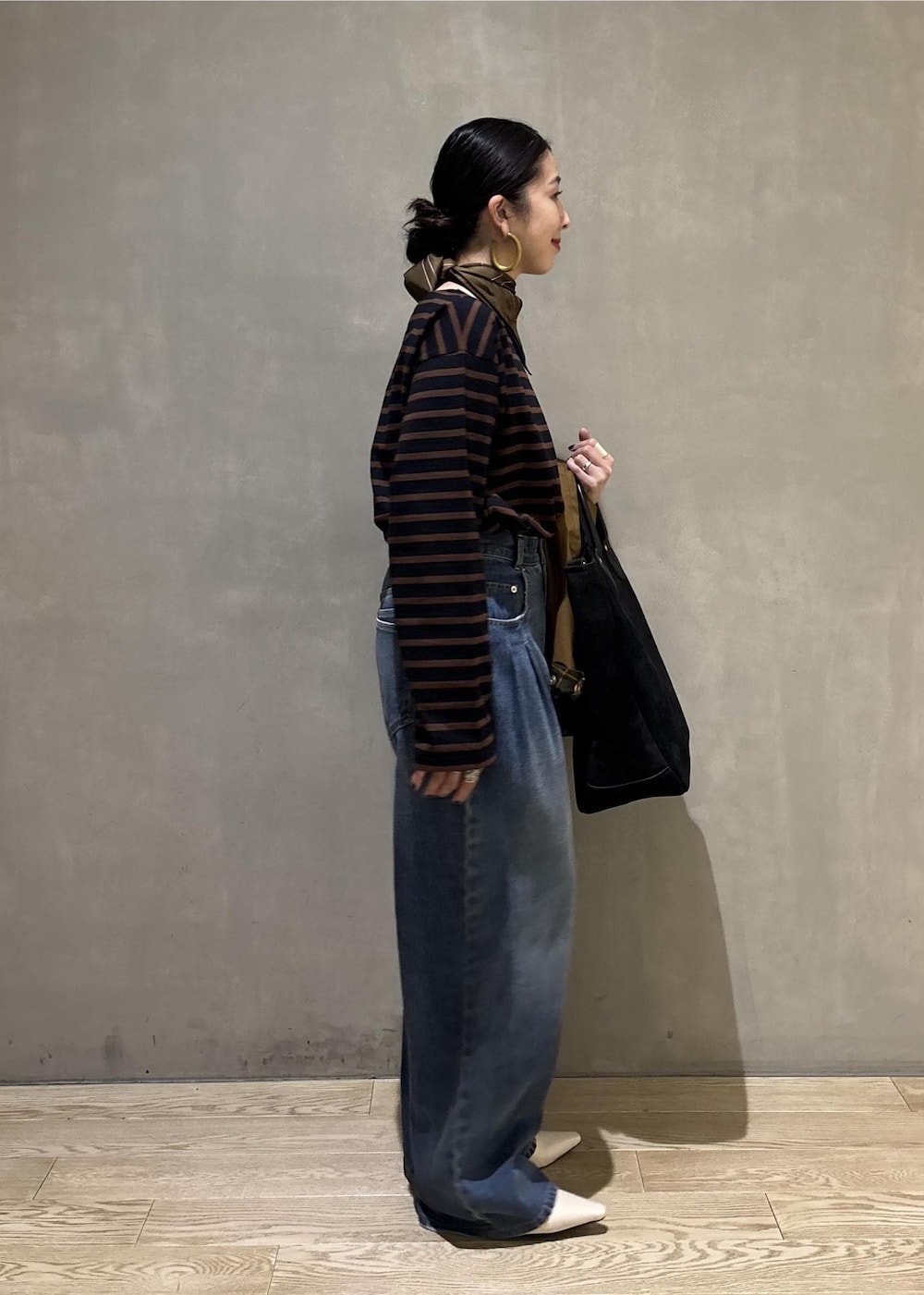 ブルー系のデニムパンツ、イエロー系のブルゾン、ブラウン系のTシャツ/カットソーを着用したレディースの夏コーディネートの4枚目の写真
