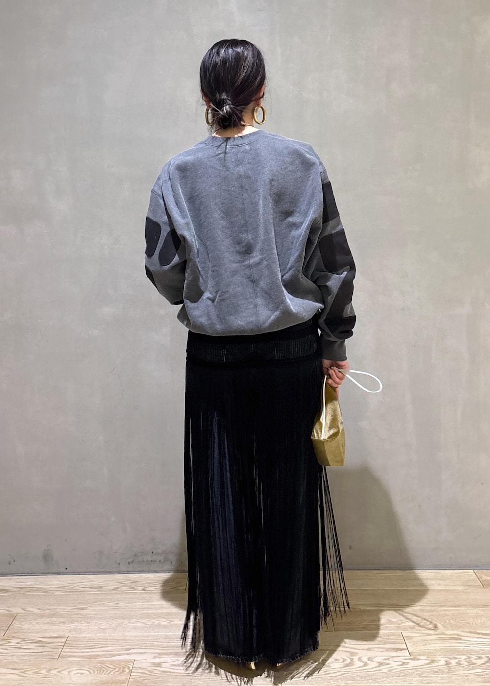 ブラック系のデニムパンツ、ブラック系のスカート、ベージュ系のポーチを着用したレディースの冬コーディネートの6枚目の写真