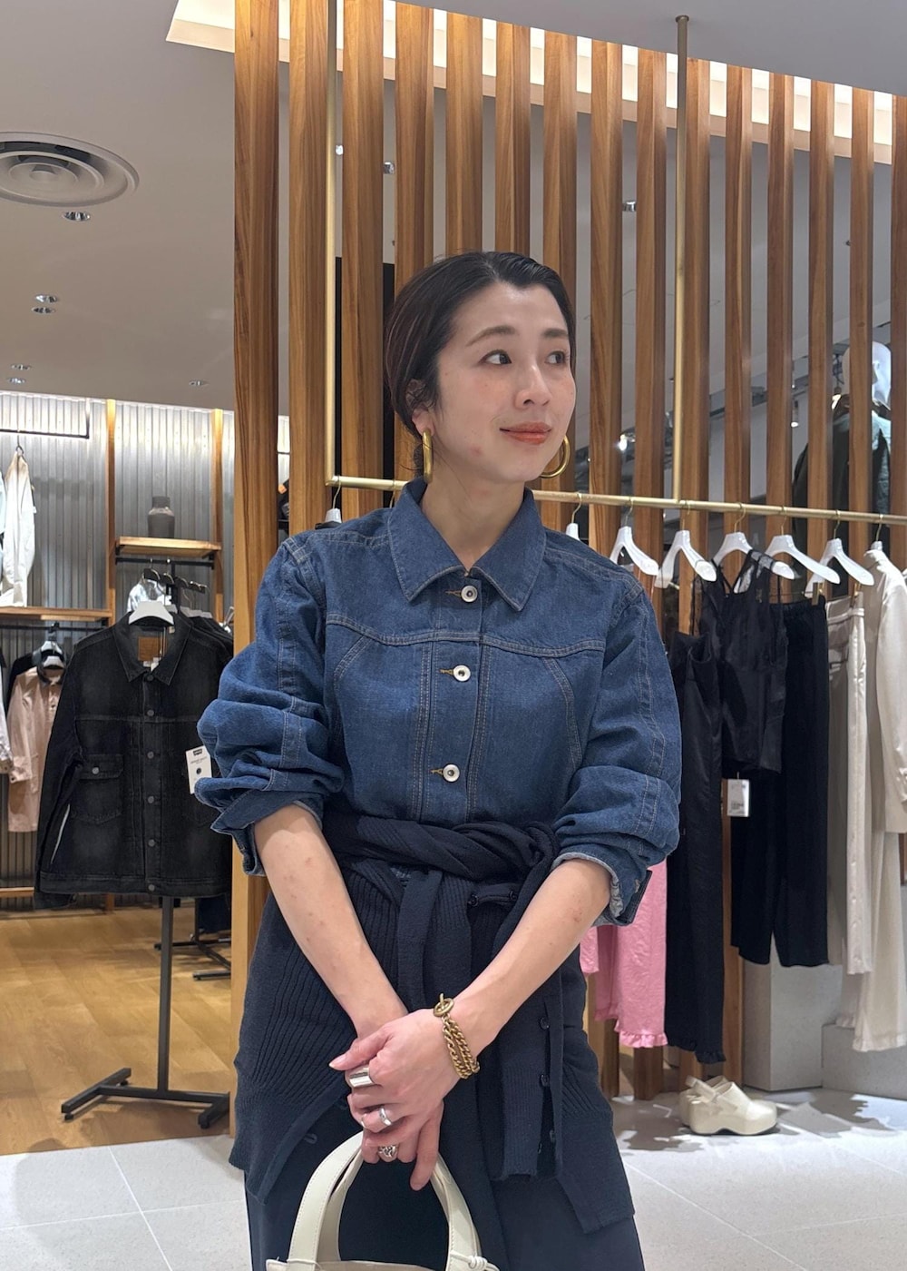 ブラック系のローファー、ホワイト系のハンドバッグ、ブルー系のブルゾンを着用したレディースの春コーディネートの9枚目の写真