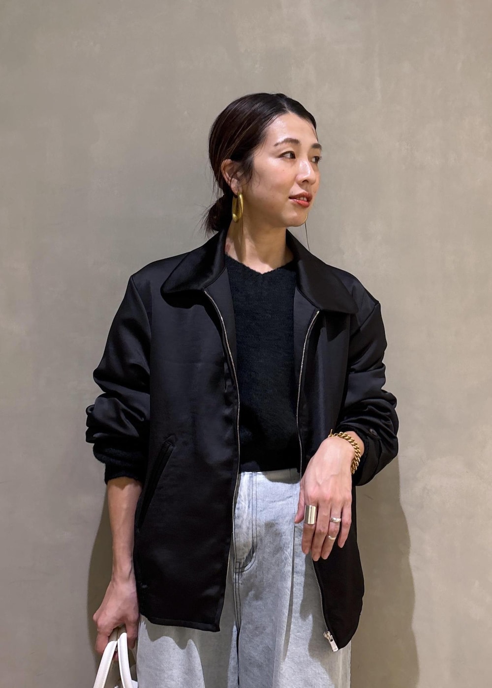 ブラック系のニット/セーター、ホワイト系のボストンバッグ、ブルー系のその他パンツを着用したレディースの冬コーディネートの10枚目の写真