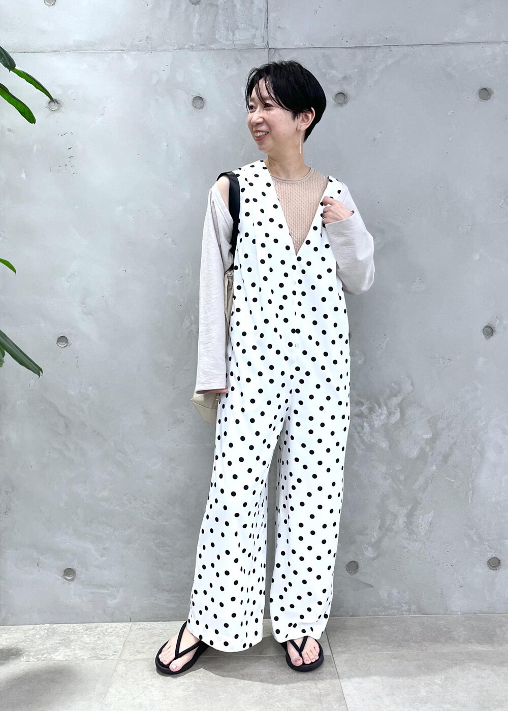 ベージュ系のトートバッグ、ホワイト系のつなぎ/オールインワン、ホワイト系のカーディガン/ボレロを着用したレディースの春コーディネートの2枚目の写真