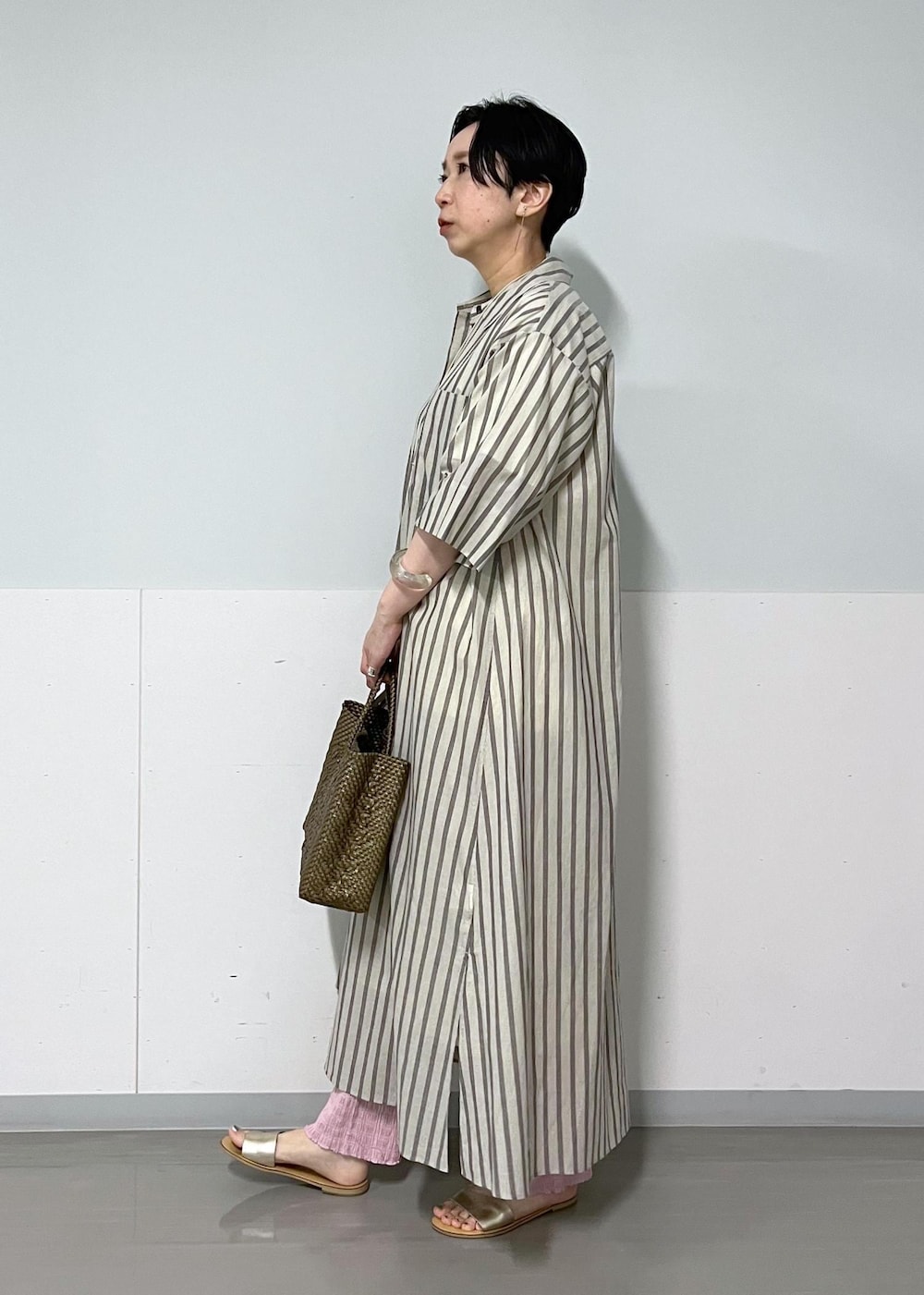 ホワイト系のシャツワンピース、その他のネックレスを着用したレディースの夏コーディネートの2枚目の写真