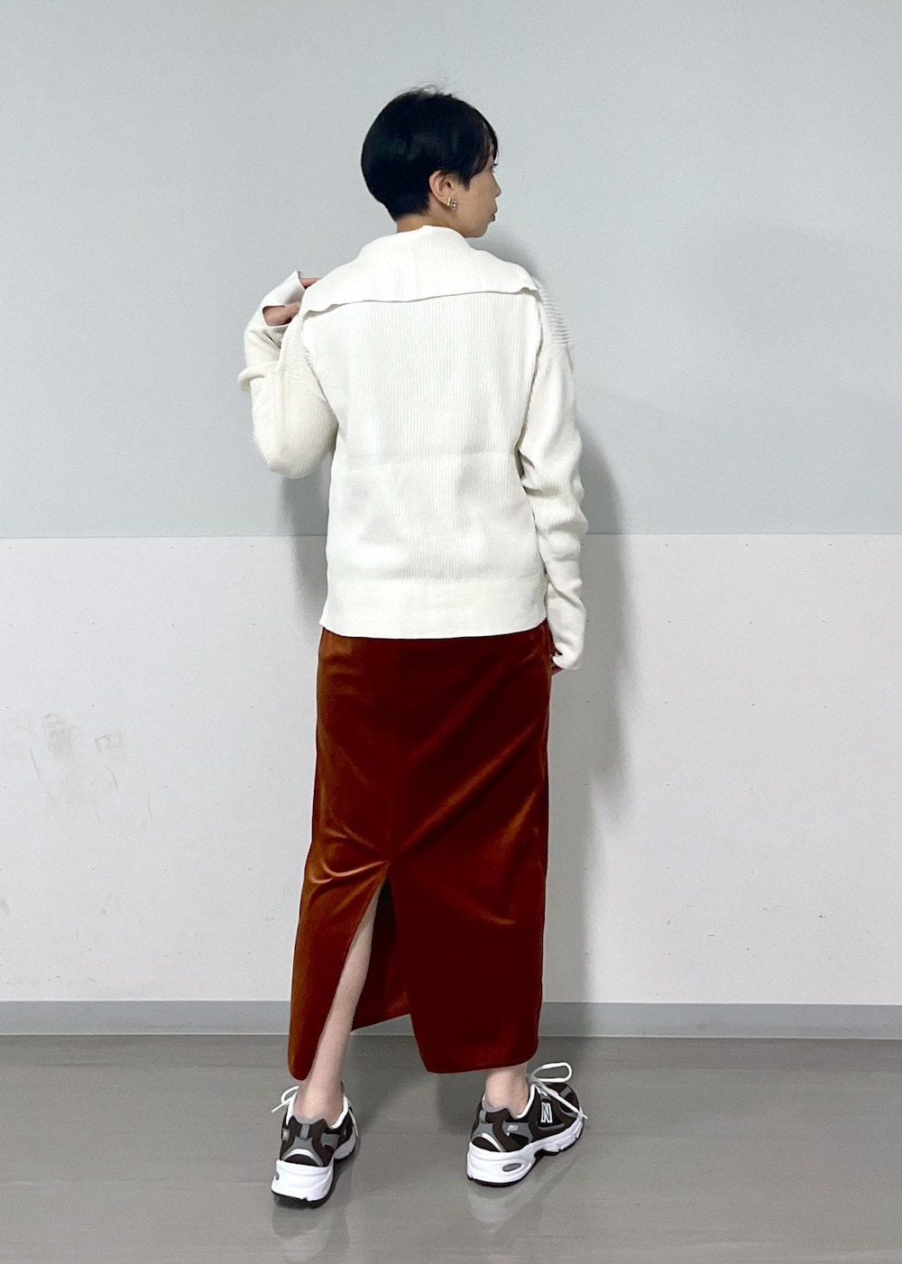 ホワイト系のニット/セーター、レッド系のスカート、レッド系のTシャツ/カットソーを着用したレディースの秋コーディネートの3枚目の写真