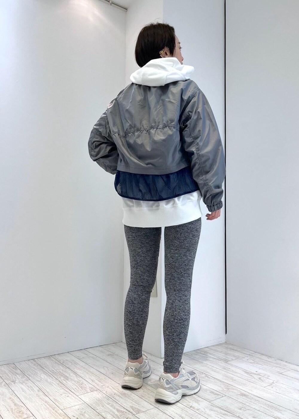 ホワイト系のパーカー、ベージュ系のスニーカー、ブルー系のブルゾンを着用したレディースの春コーディネートの3枚目の写真