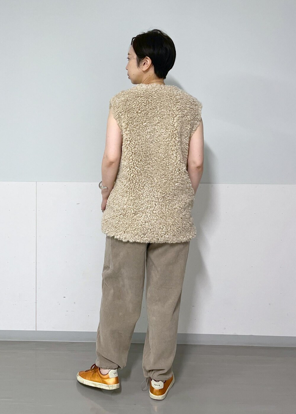 ベージュ系のベスト、グレー系のキャミソール、グレー系のカーゴパンツを着用したレディースの秋コーディネートの2枚目の写真