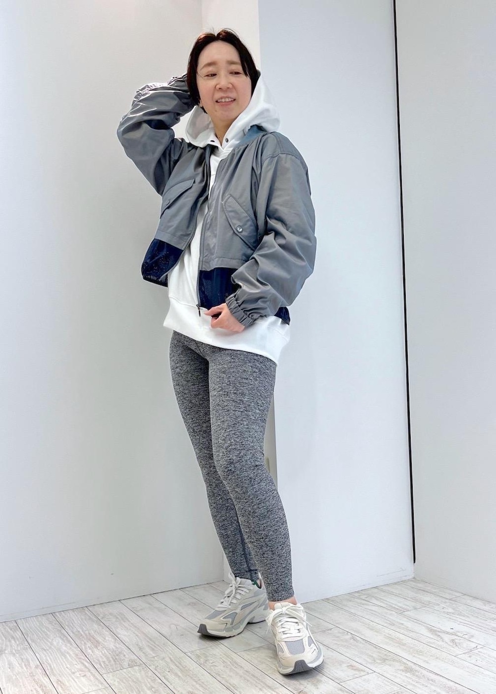 ホワイト系のパーカー、ベージュ系のスニーカー、ブルー系のブルゾンを着用したレディースの春コーディネートの2枚目の写真