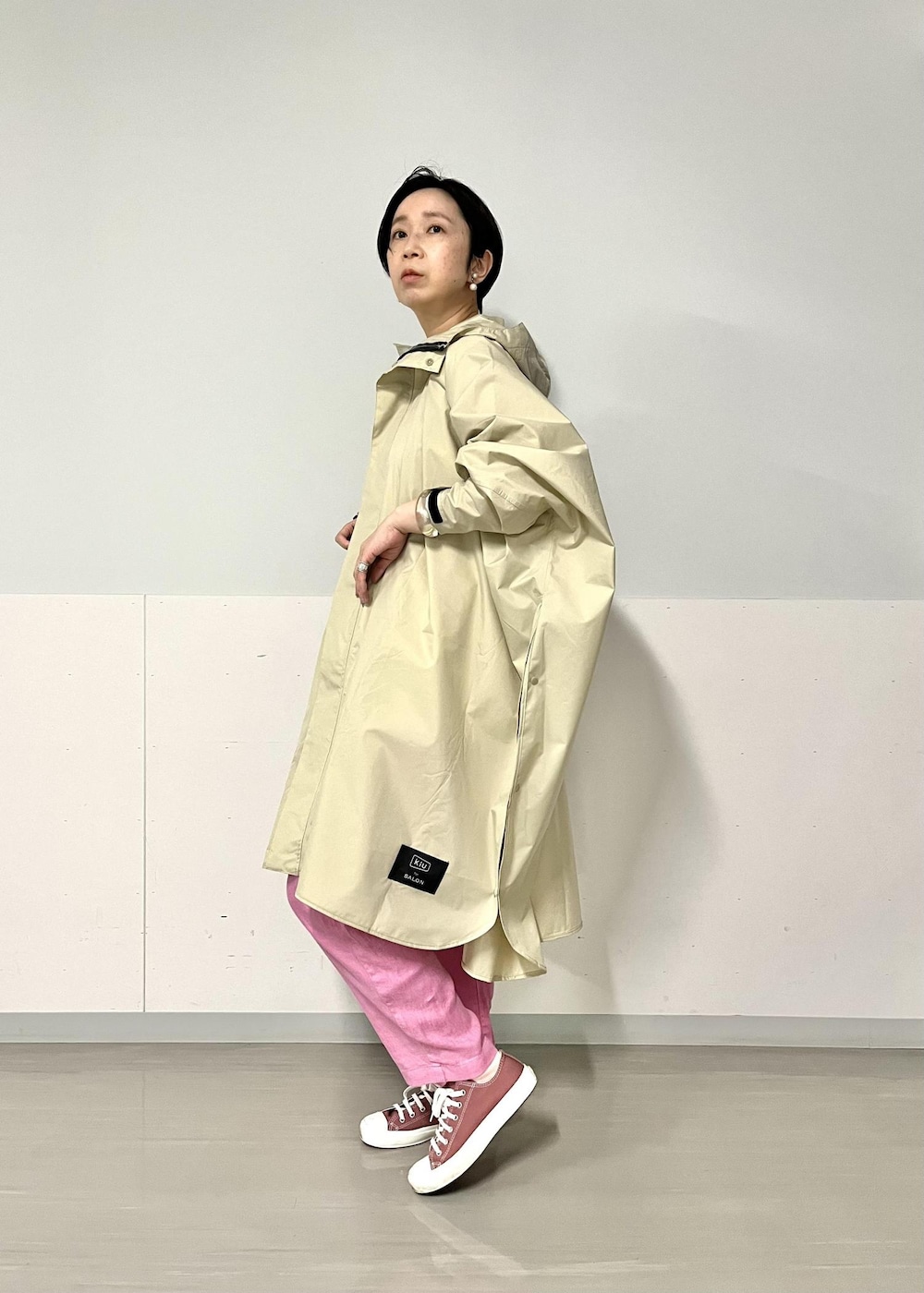 ピンク系のその他パンツ、ピンク系のトートバッグ、ベージュ系のレインコート/ポンチョを着用したレディースの春コーディネートの2枚目の写真