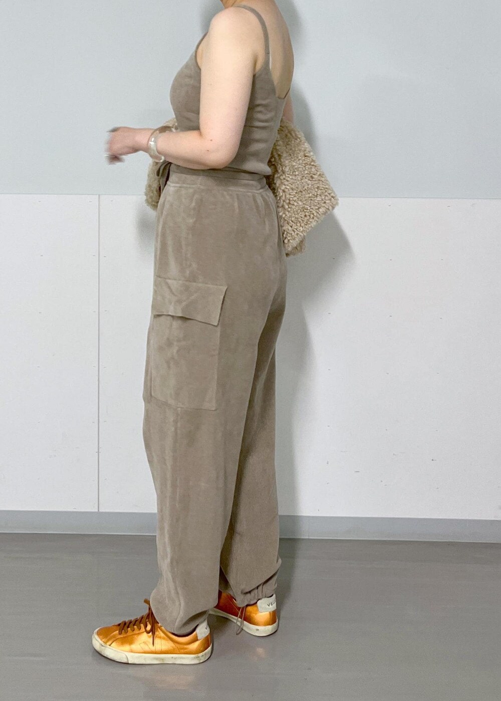 ベージュ系のベスト、グレー系のキャミソール、グレー系のカーゴパンツを着用したレディースの秋コーディネートの7枚目の写真