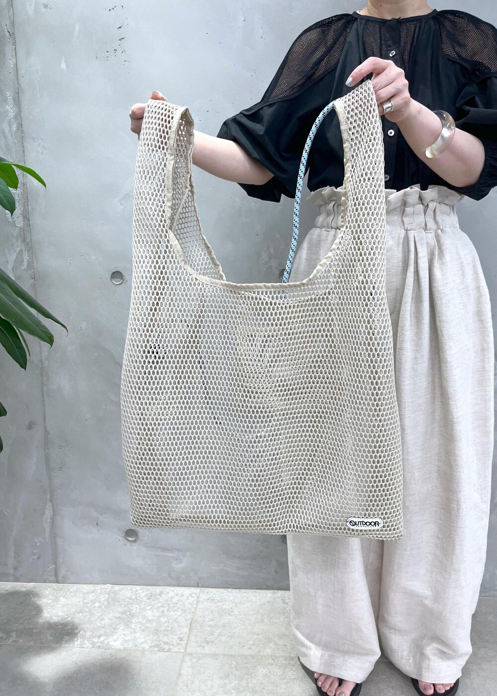 ホワイト系のスラックス、ブラック系のシャツ/ブラウスを着用したレディースの春コーディネートの7枚目の写真