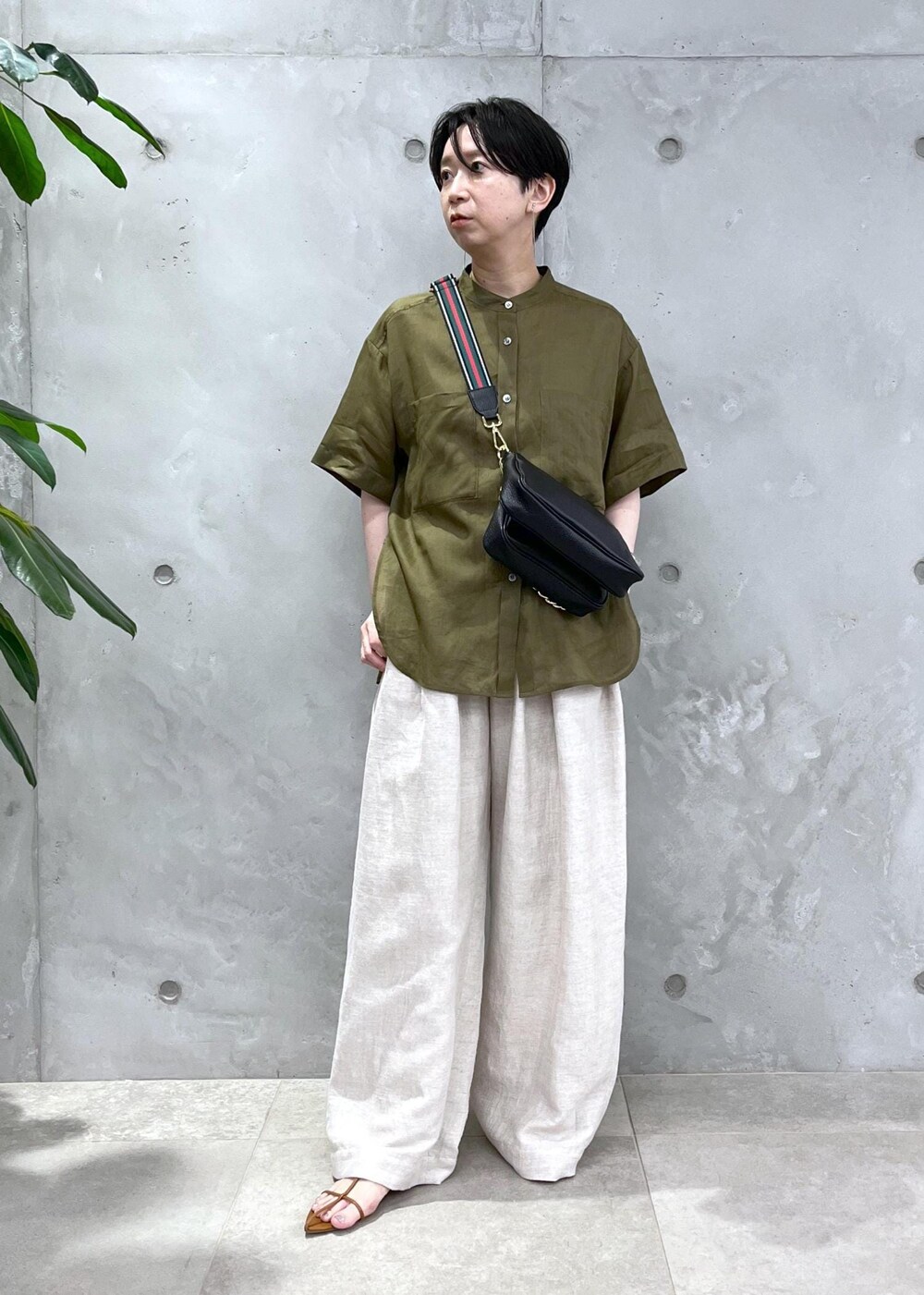 ホワイト系のスラックス、グリーン系のシャツ/ブラウスを着用したレディースの春コーディネートの2枚目の写真