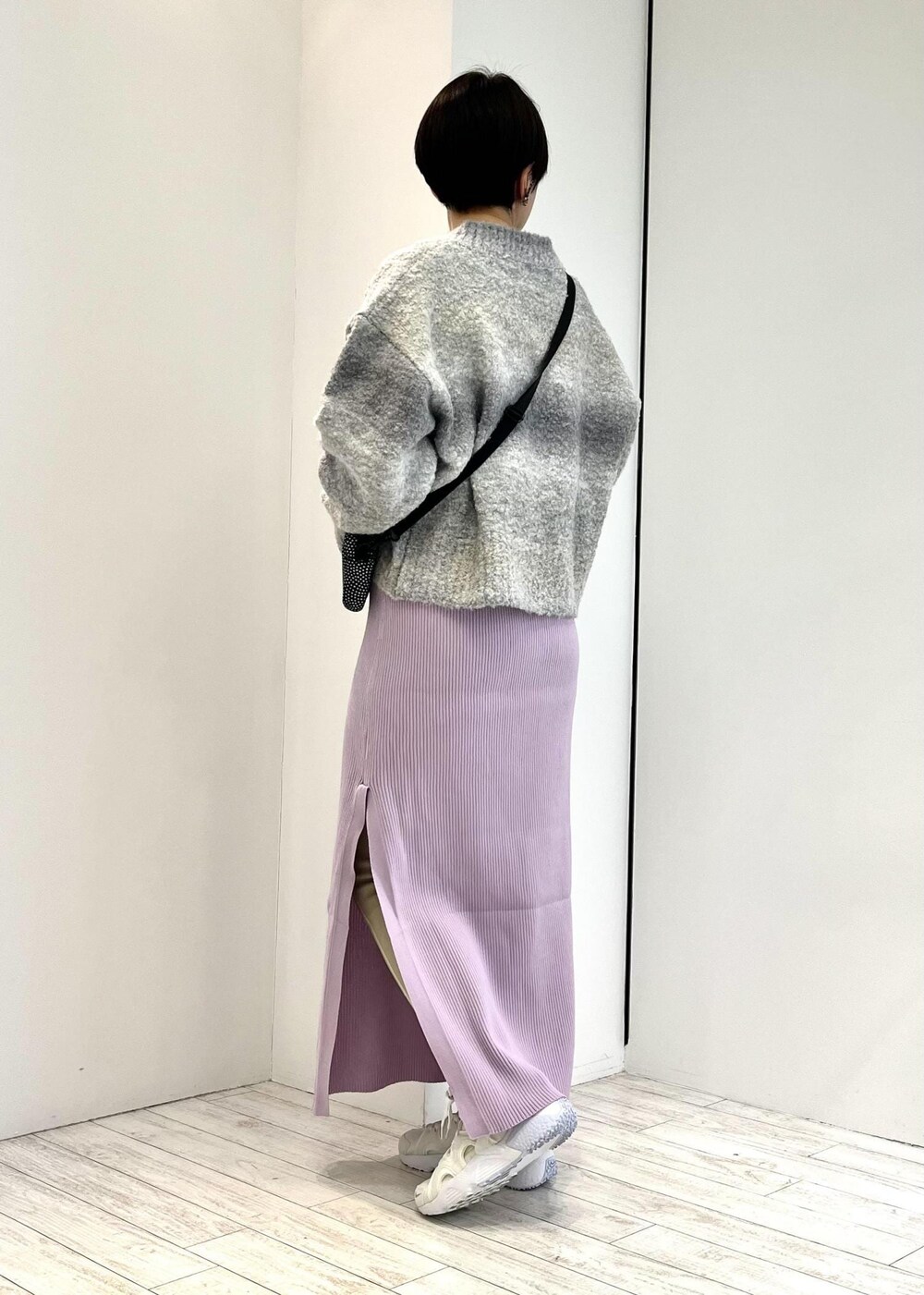 ブラック系のショルダーバッグ、グレー系のニット/セーター、パープル系のワンピースを着用したレディースの冬コーディネートの3枚目の写真