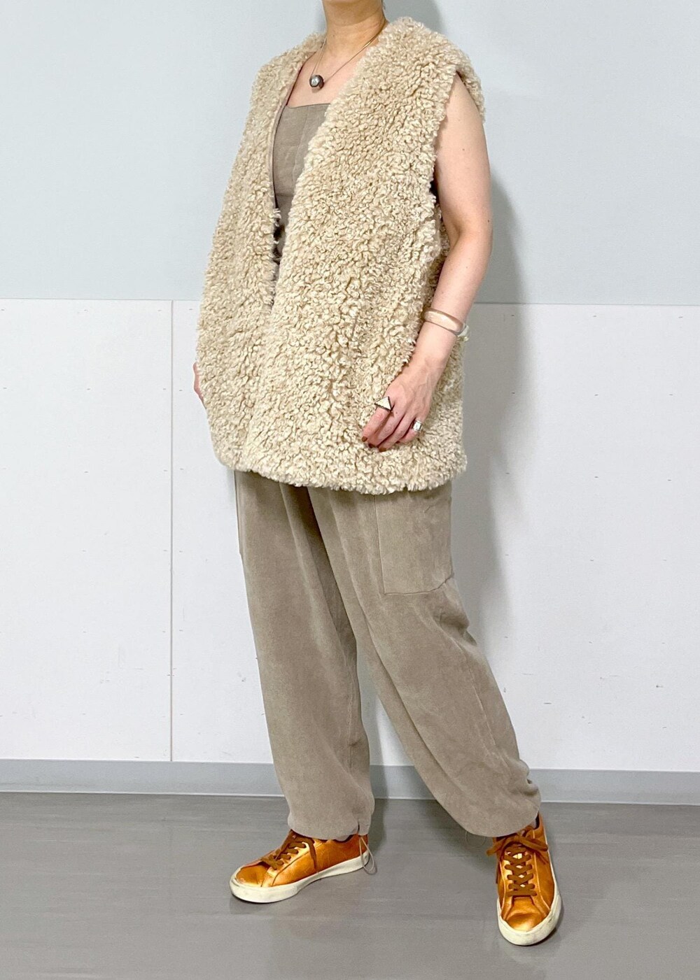 ベージュ系のベスト、グレー系のキャミソール、グレー系のカーゴパンツを着用したレディースの秋コーディネートの3枚目の写真