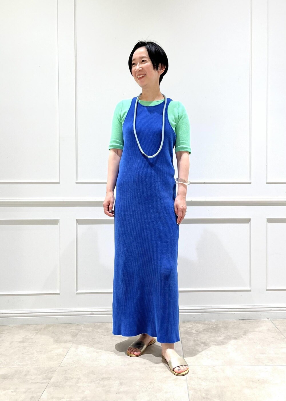 ブルー系のワンピース、グリーン系のTシャツ/カットソーを着用したレディースの春コーディネートの2枚目の写真