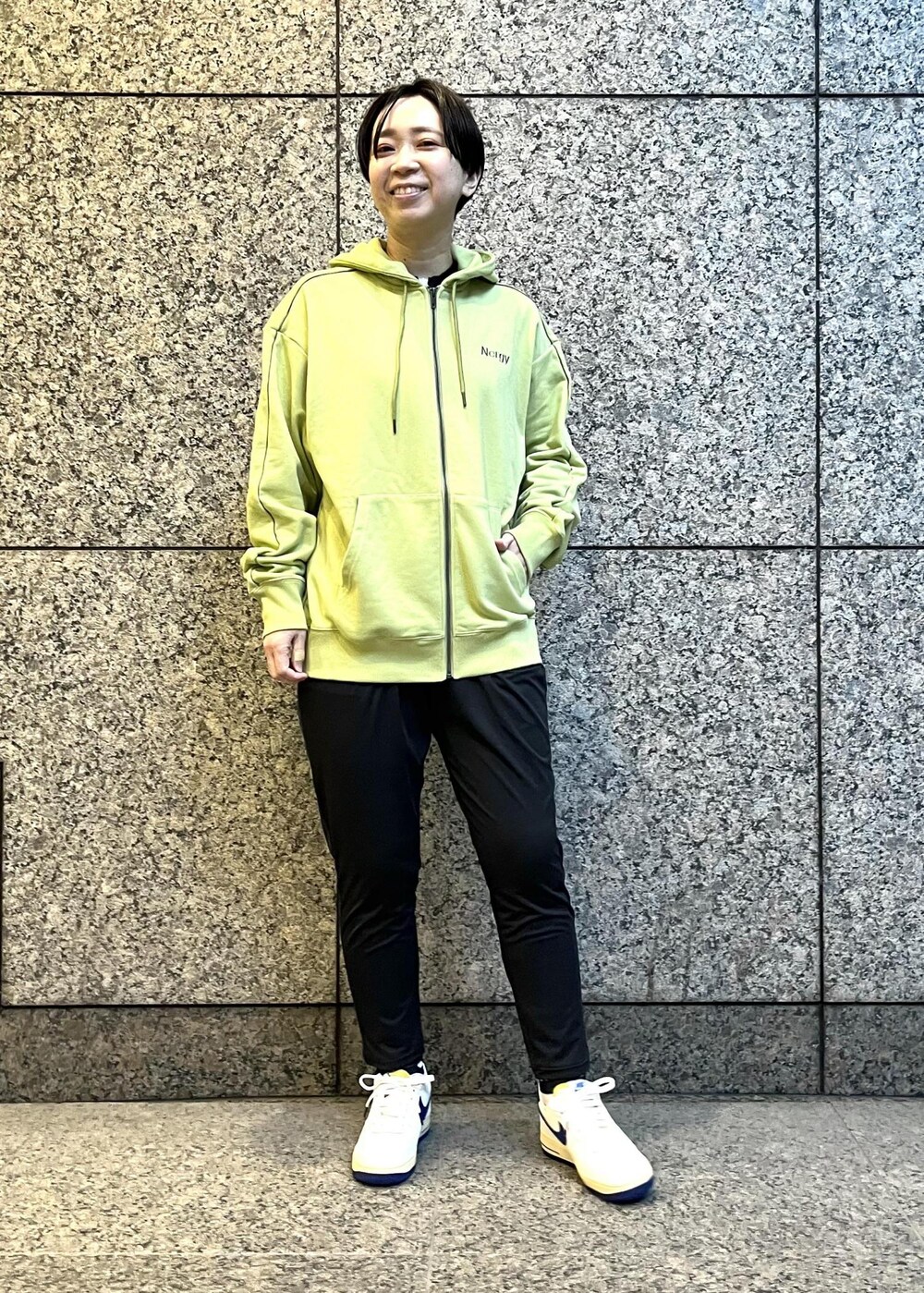 ブラック系のその他パンツ、グリーン系のパーカー、ホワイト系のスニーカーを着用したレディースの冬コーディネートの2枚目の写真