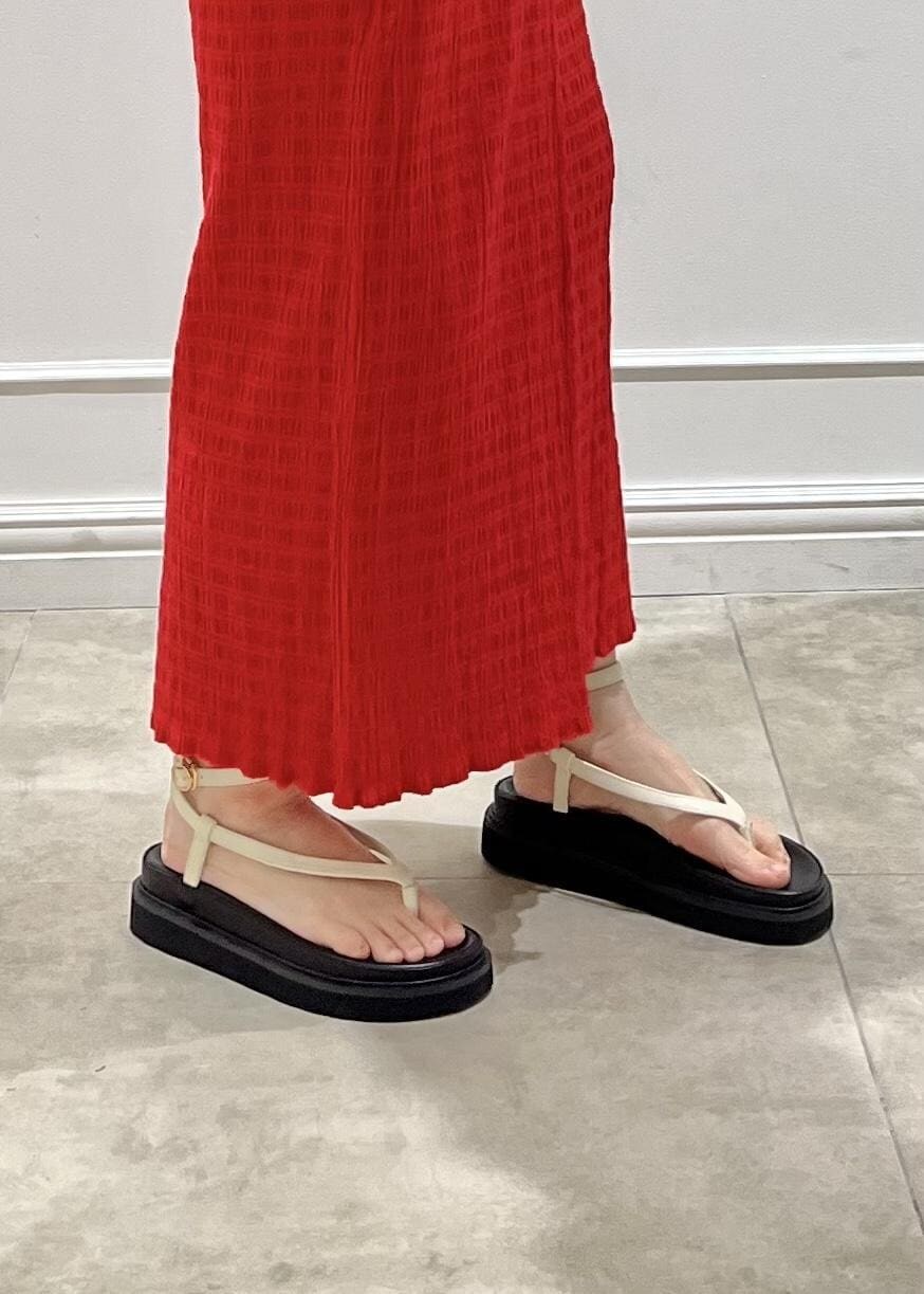 ホワイト系のサンダル、レッド系のスカート、グリーン系のTシャツ/カットソーを着用したレディースの春コーディネートの8枚目の写真