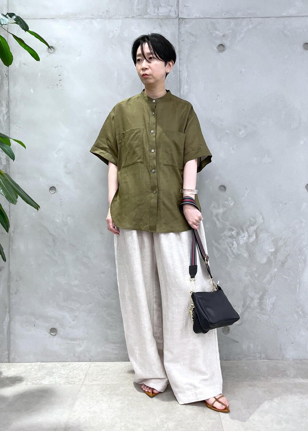ホワイト系のスラックス、グリーン系のシャツ/ブラウスを着用したレディースの春コーディネートの3枚目の写真