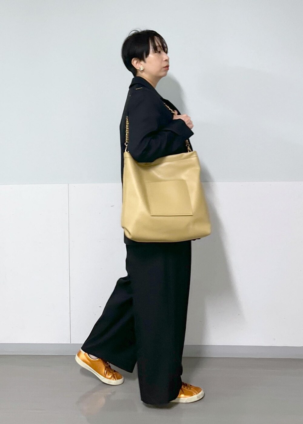 ブラック系のテーラードジャケット、ブラック系のスラックス、レッド系のTシャツ/カットソーを着用したレディースの秋コーディネートの2枚目の写真