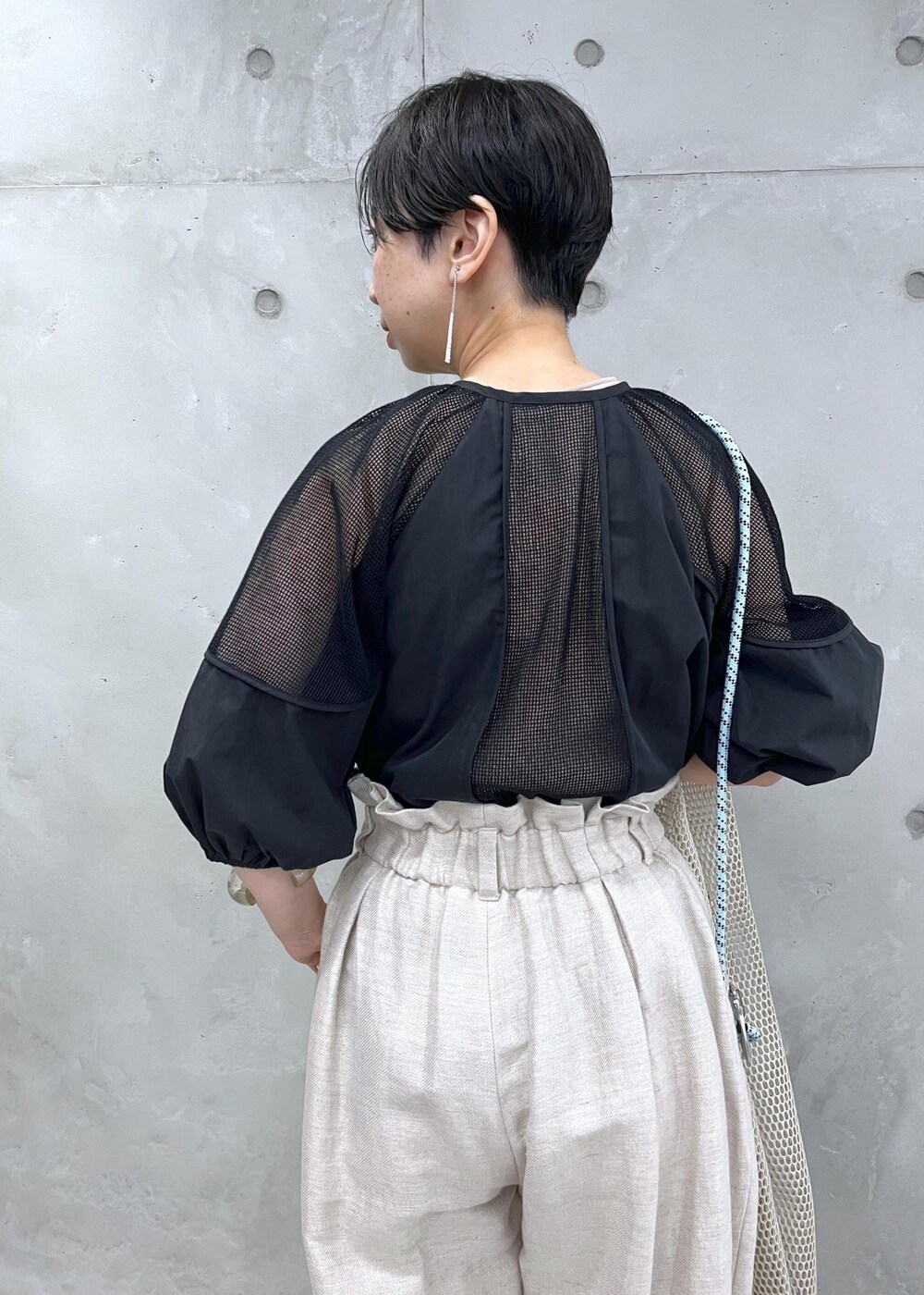 ホワイト系のスラックス、ブラック系のシャツ/ブラウスを着用したレディースの春コーディネートの4枚目の写真