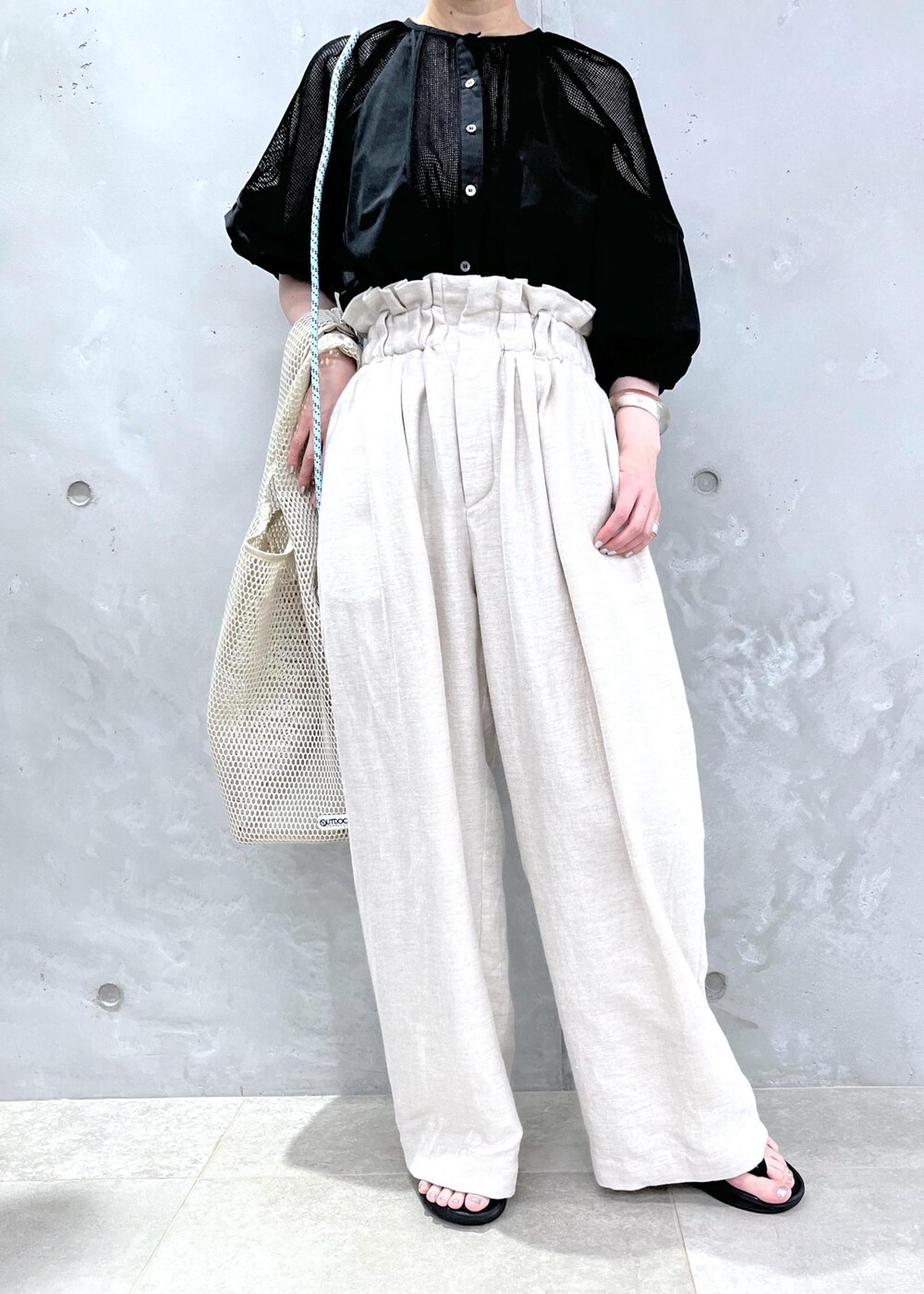 ホワイト系のスラックス、ブラック系のシャツ/ブラウスを着用したレディースの春コーディネートの6枚目の写真