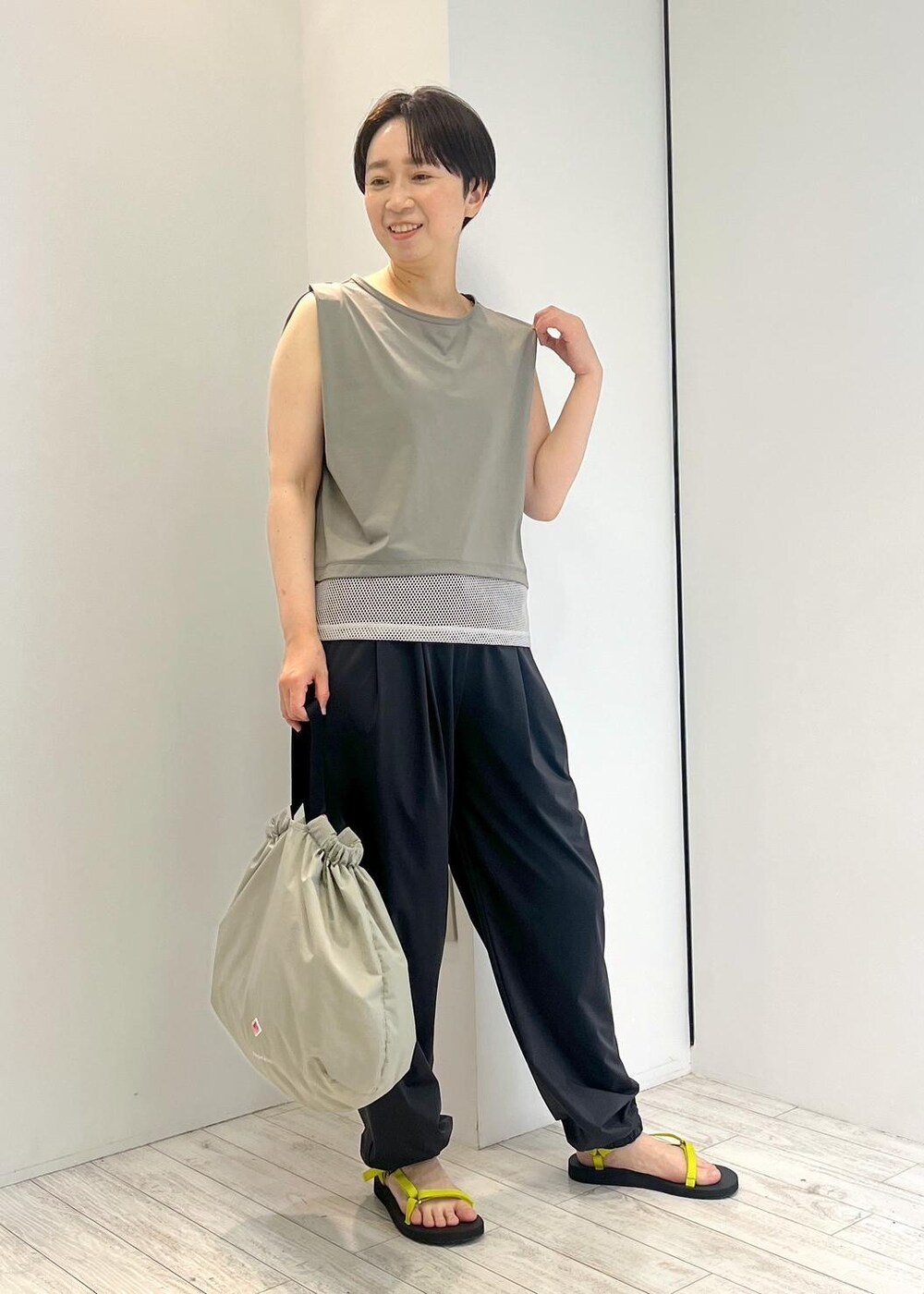 グリーン系のTシャツ/カットソー、ブラック系のカーゴパンツ、ブラック系のサンダルを着用したレディースの夏コーディネートの2枚目の写真