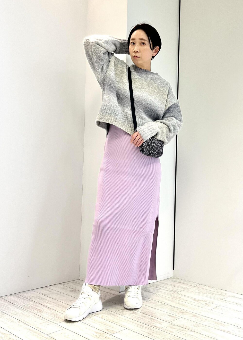 ブラック系のショルダーバッグ、グレー系のニット/セーター、パープル系のワンピースを着用したレディースの冬コーディネートの2枚目の写真