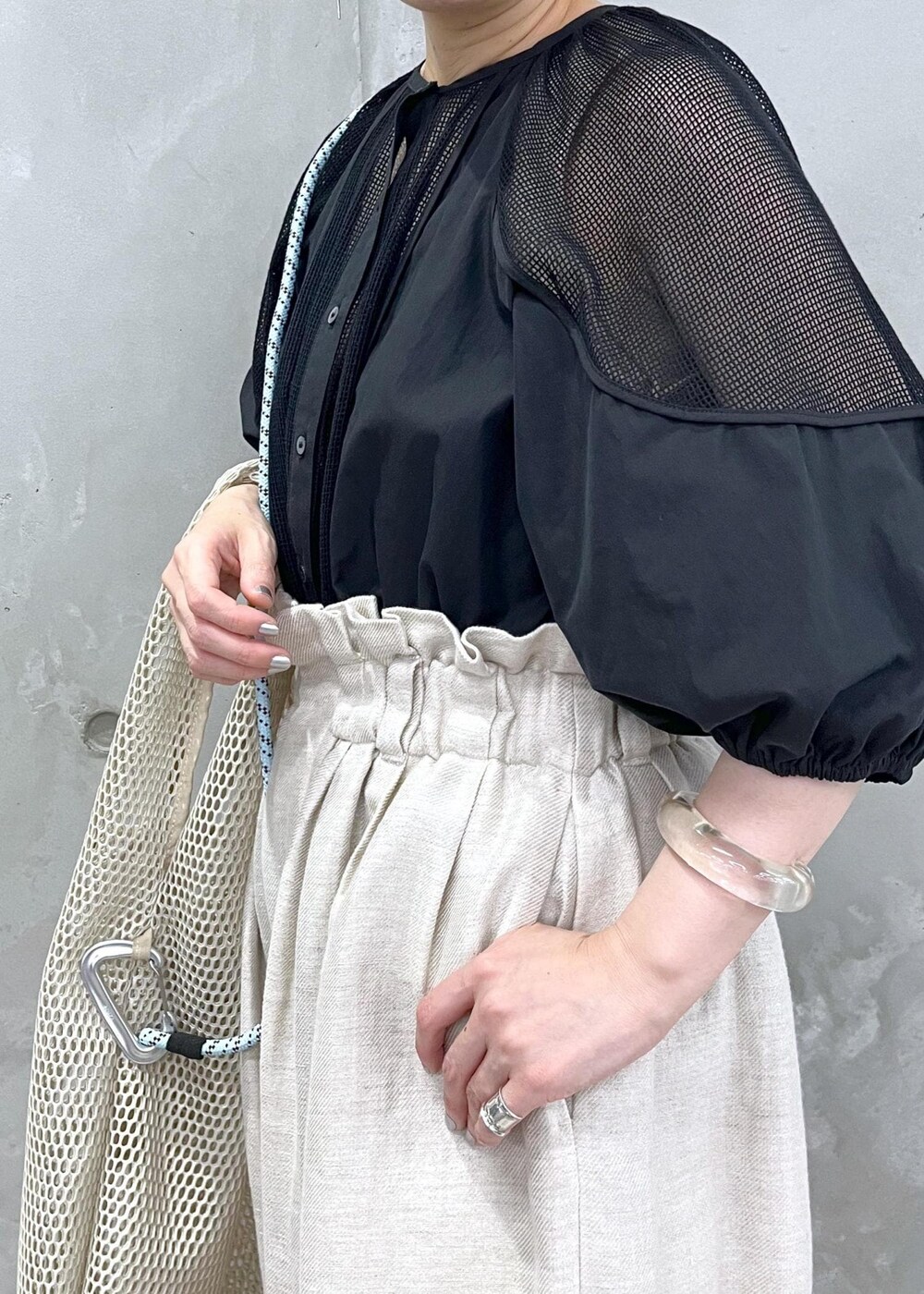 ホワイト系のスラックス、ブラック系のシャツ/ブラウスを着用したレディースの春コーディネートの5枚目の写真