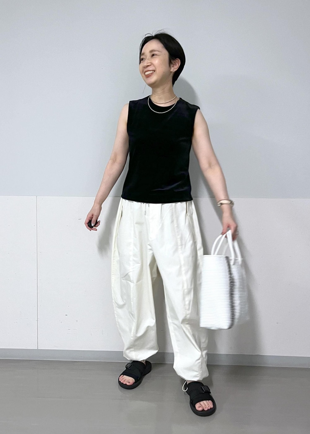 ホワイト系のカーゴパンツ、ベージュ系のショルダーバッグ、ベージュ系のカーディガン/ボレロを着用したレディースの夏コーディネートの3枚目の写真