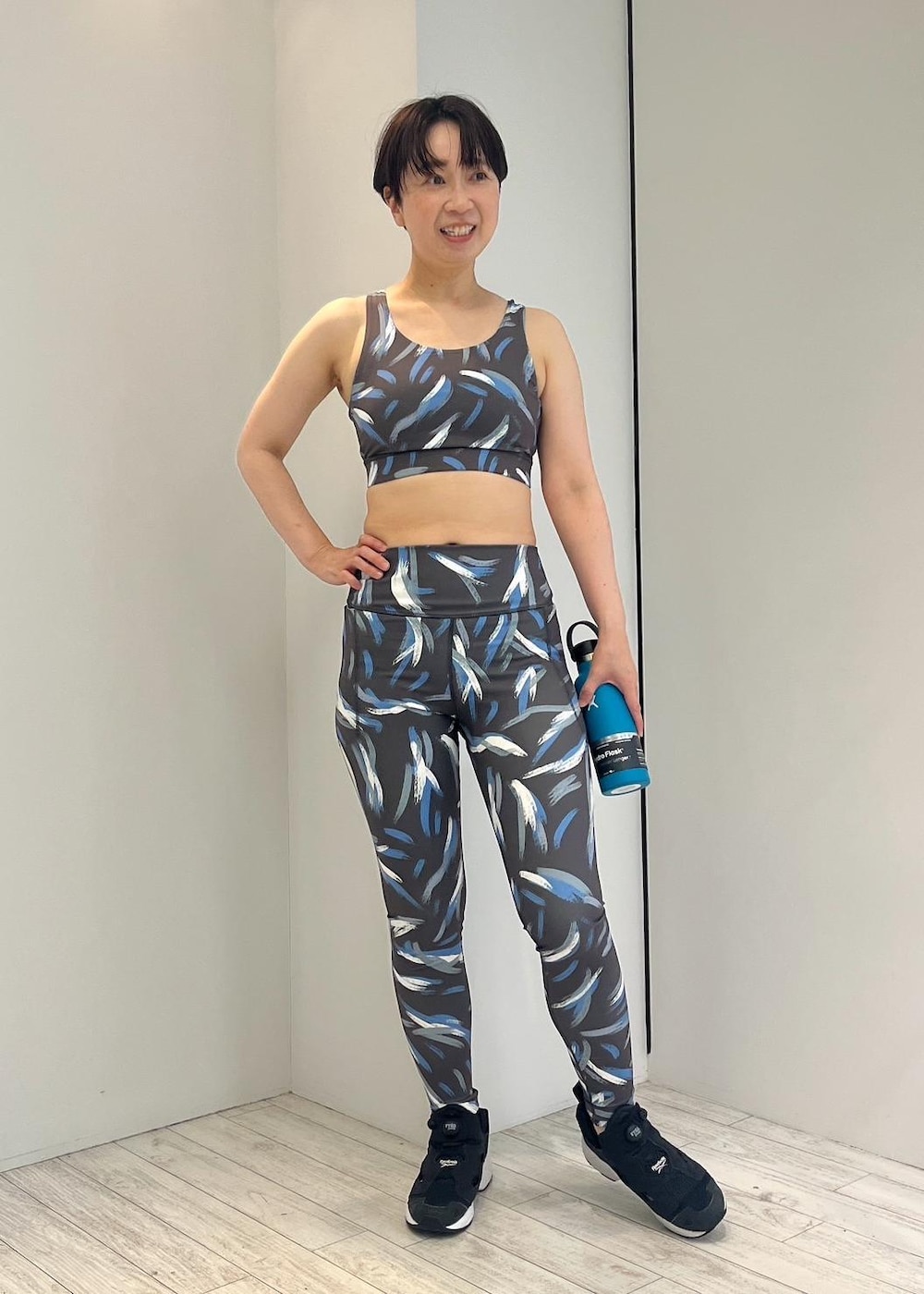 ブラック系のスニーカー、ブラック系のレギンス/スパッツ、ブラック系のスポーツブラを着用したレディースの夏コーディネートの3枚目の写真