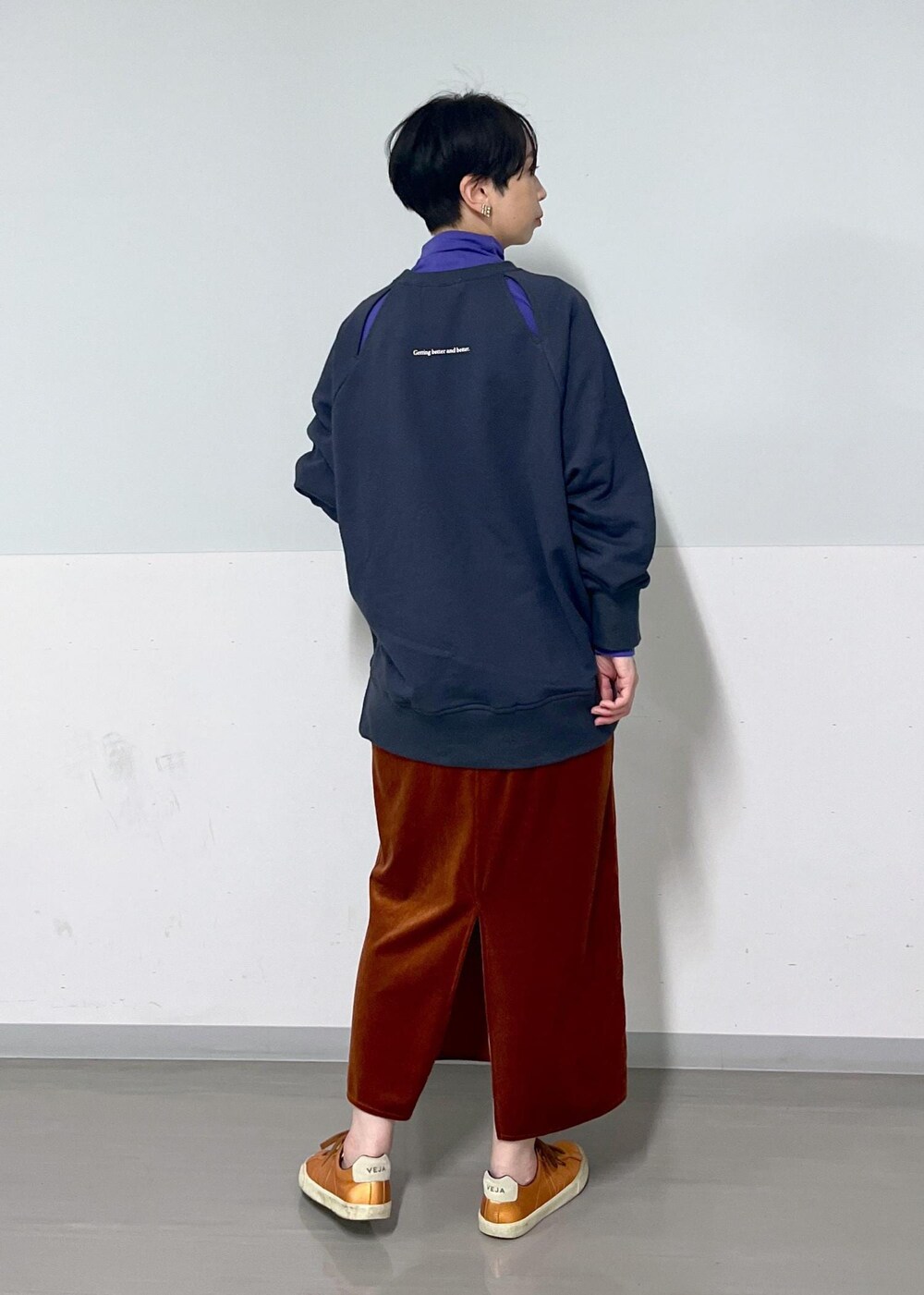 レッド系のスカート、グレー系のスウェット、パープル系のTシャツ/カットソーを着用したレディースの秋コーディネートの3枚目の写真