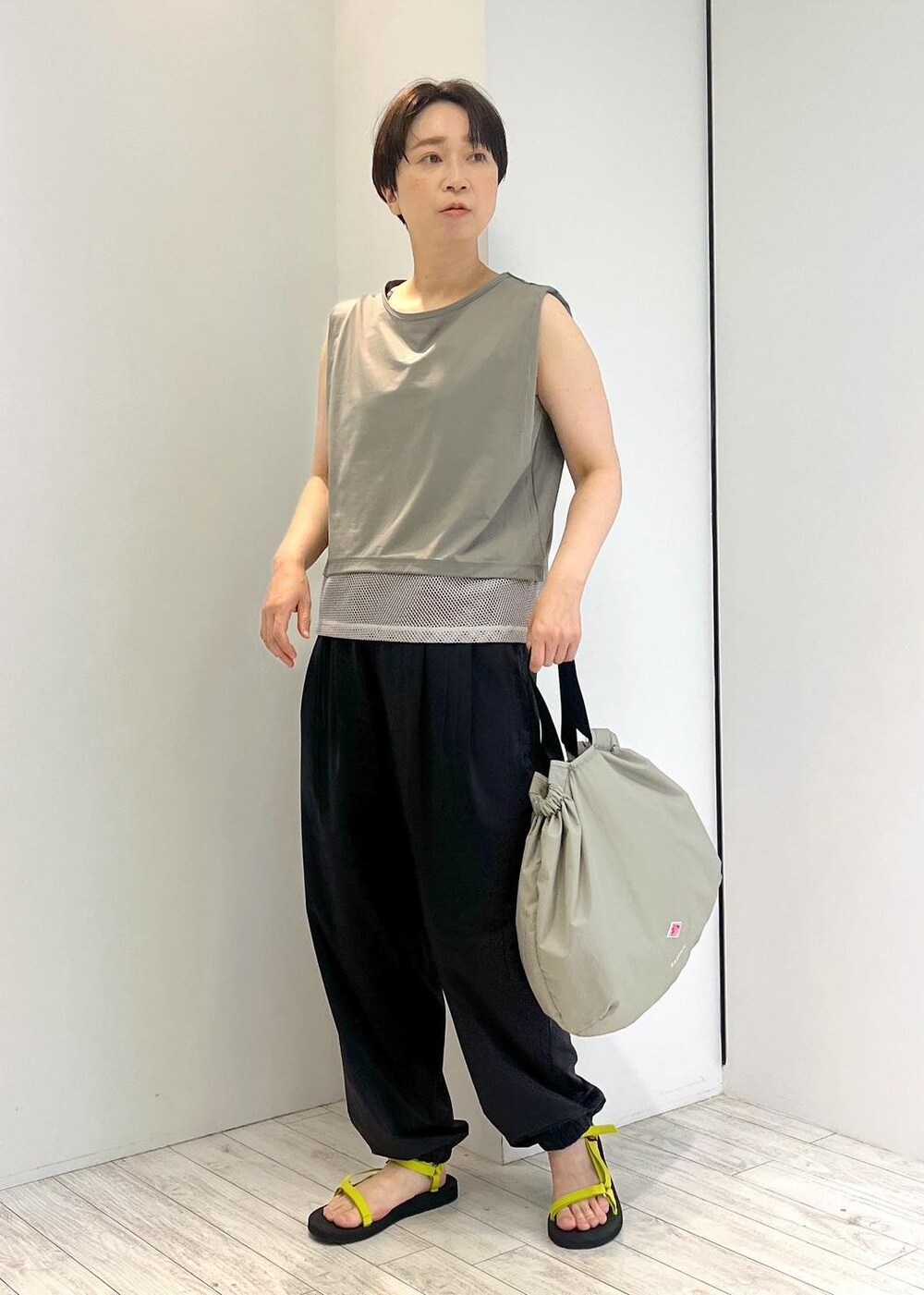 グリーン系のTシャツ/カットソー、ブラック系のカーゴパンツ、ブラック系のサンダルを着用したレディースの夏コーディネートの4枚目の写真