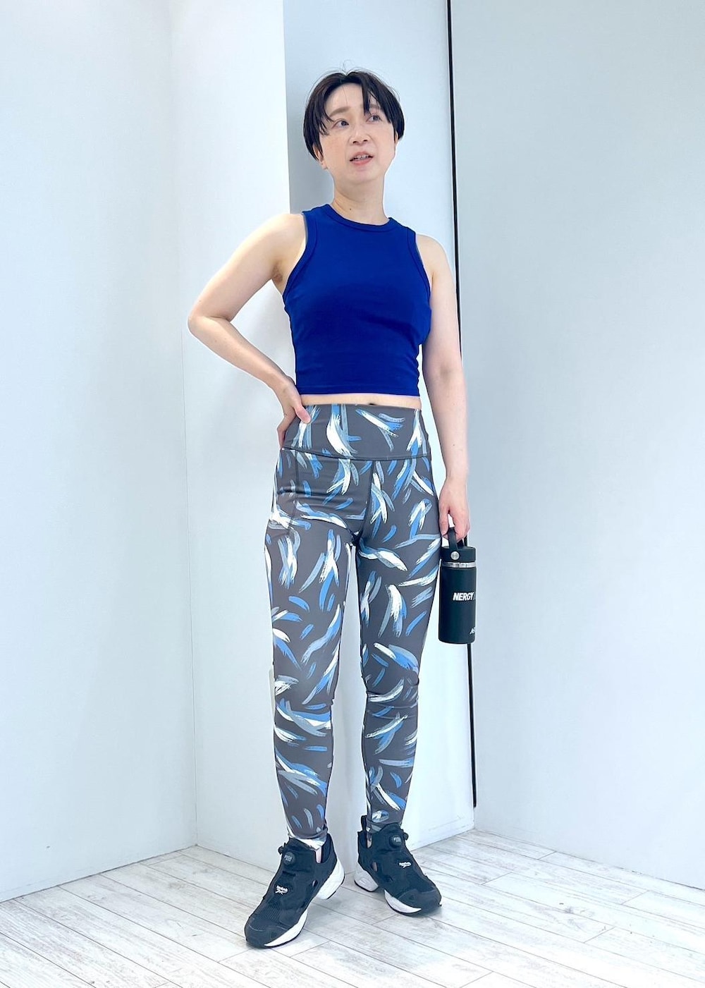 ブラック系のスニーカー、グレー系のTシャツ/カットソー、ブルー系のタンクトップを着用したレディースの夏コーディネートの3枚目の写真