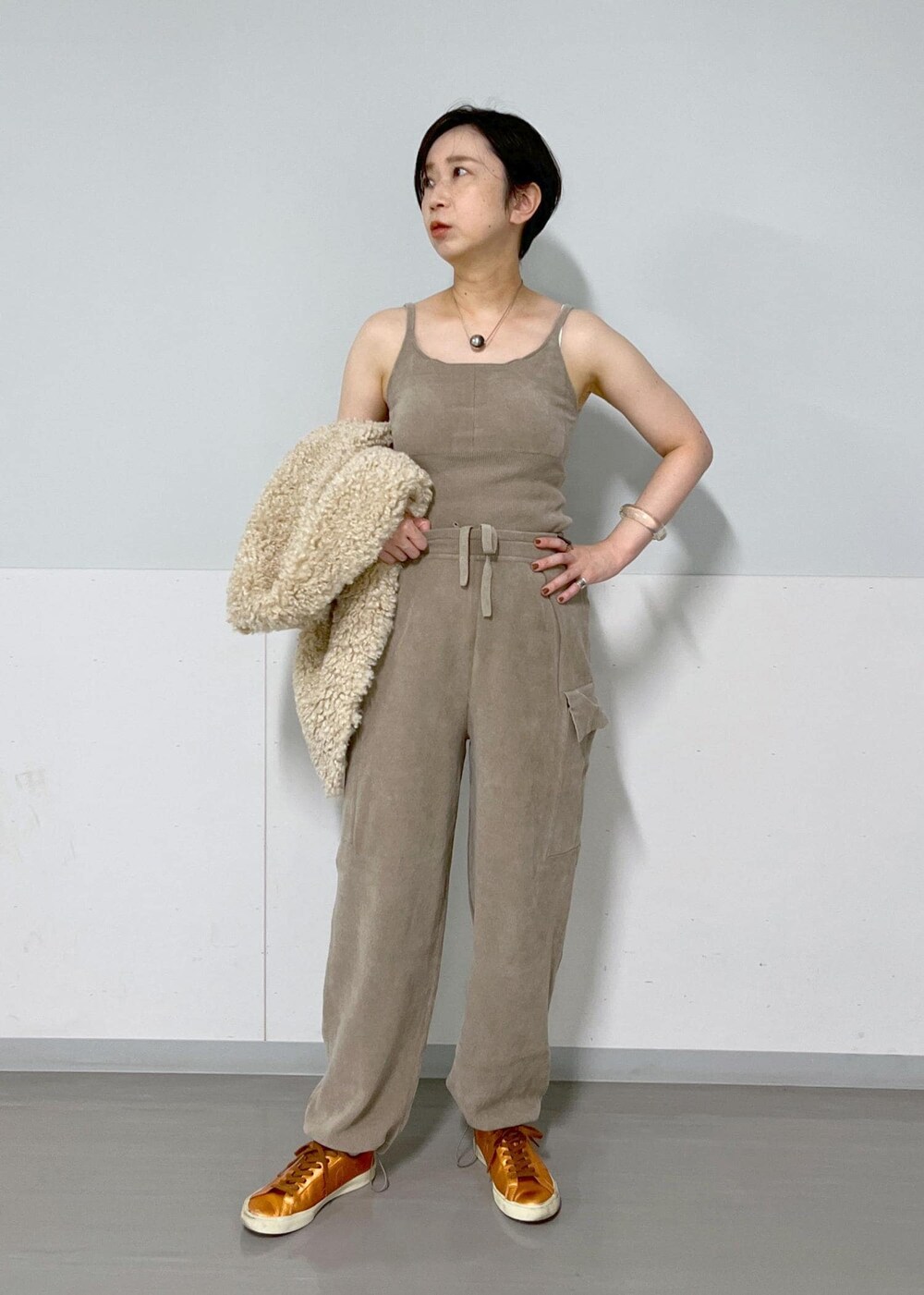 ベージュ系のベスト、グレー系のキャミソール、グレー系のカーゴパンツを着用したレディースの秋コーディネートの4枚目の写真