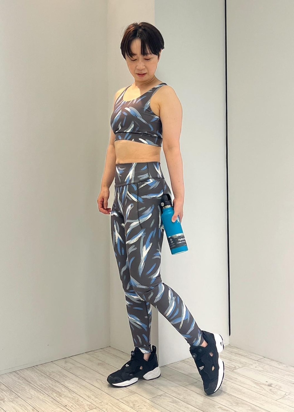 ブラック系のスニーカー、ブラック系のレギンス/スパッツ、ブラック系のスポーツブラを着用したレディースの夏コーディネートの2枚目の写真