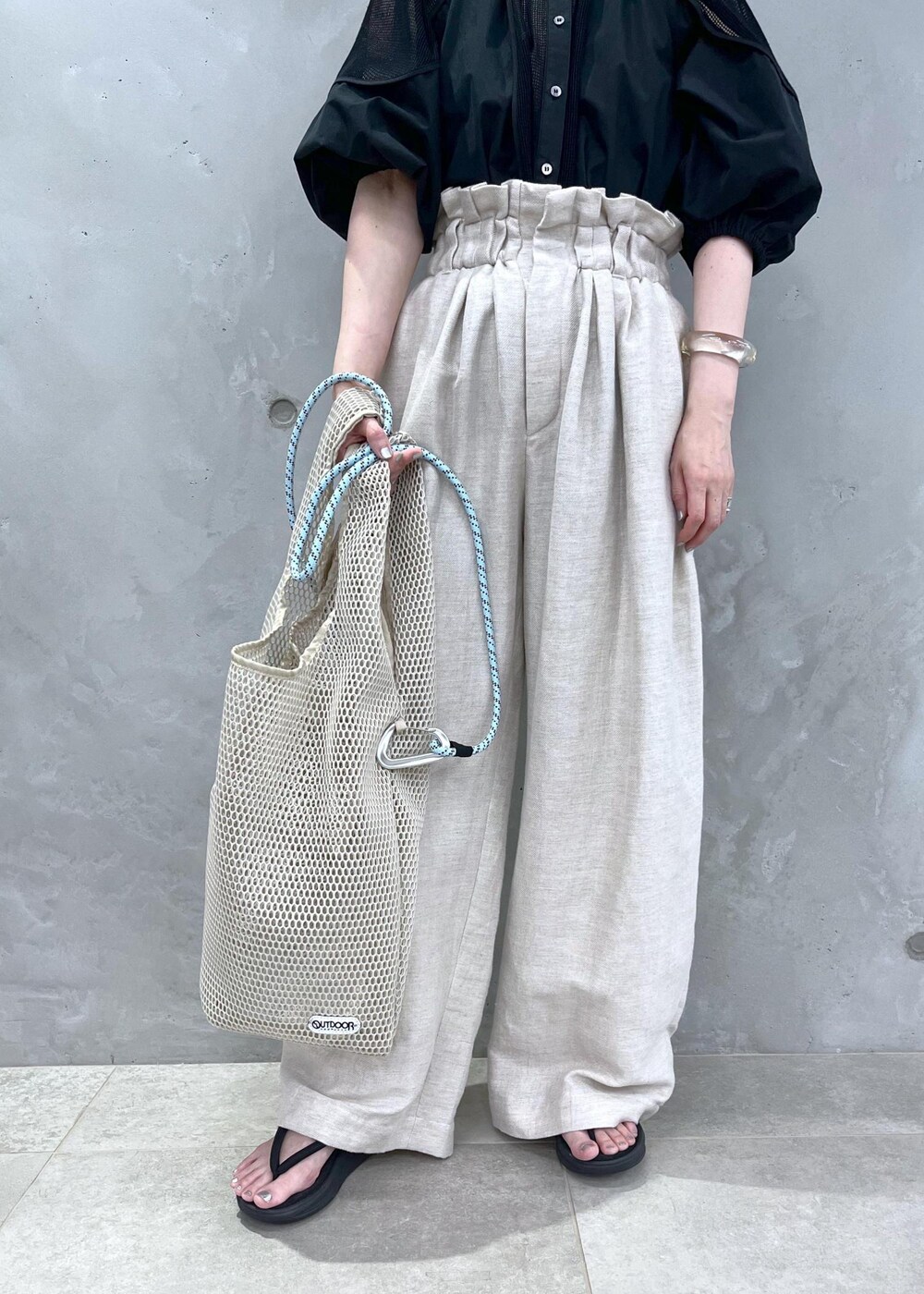 ホワイト系のスラックス、ブラック系のシャツ/ブラウスを着用したレディースの春コーディネートの8枚目の写真