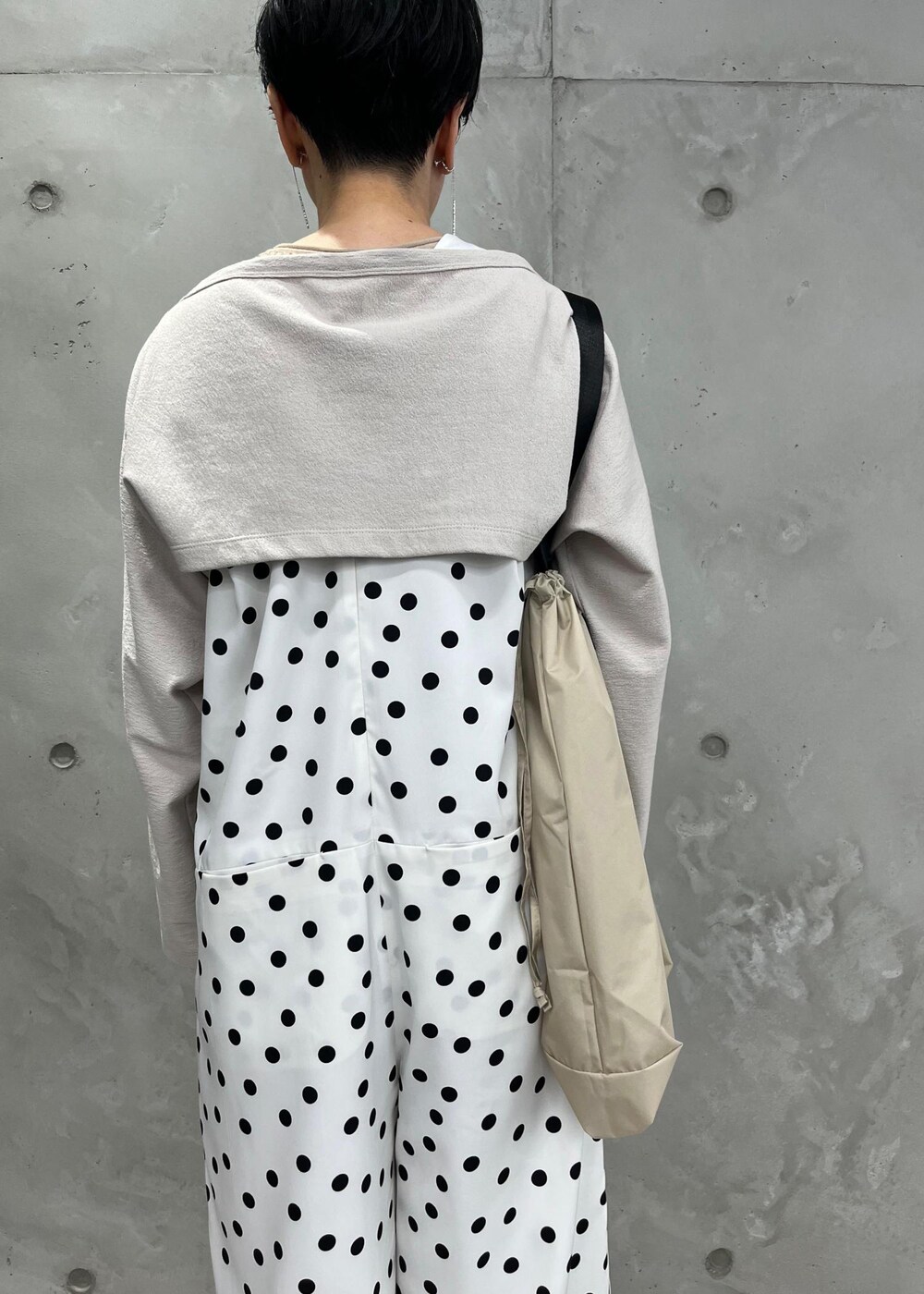 ベージュ系のトートバッグ、ホワイト系のつなぎ/オールインワン、ホワイト系のカーディガン/ボレロを着用したレディースの春コーディネートの4枚目の写真