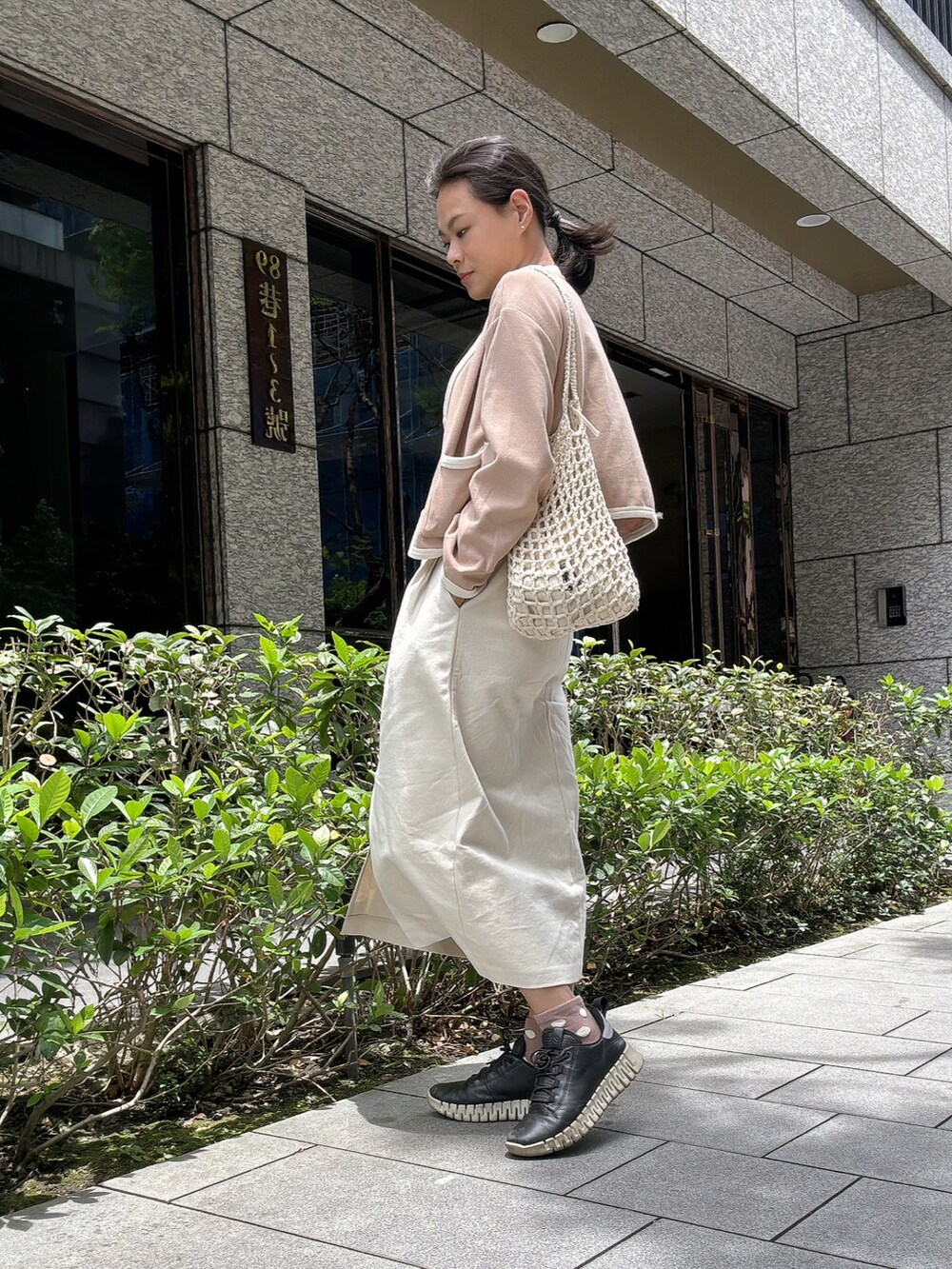 ブラック系のその他トップス、その他のノーカラージャケット、ホワイト系のスカートを着用したレディースの春コーディネートの2枚目の写真