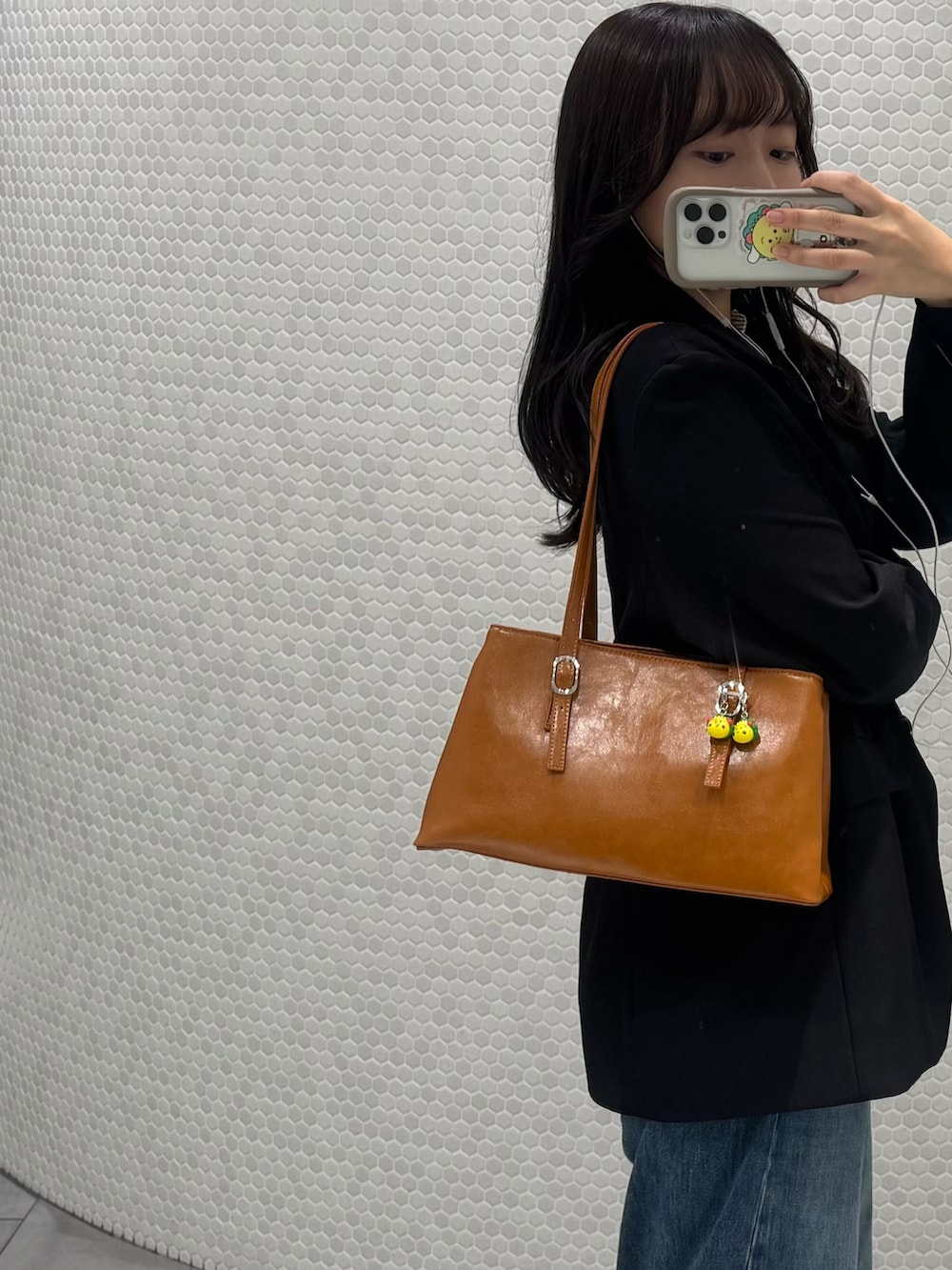 ブラック系のその他アウター、イエロー系のハンドバッグ、ブラウン系のローファーを着用したレディースの秋コーディネートの2枚目の写真