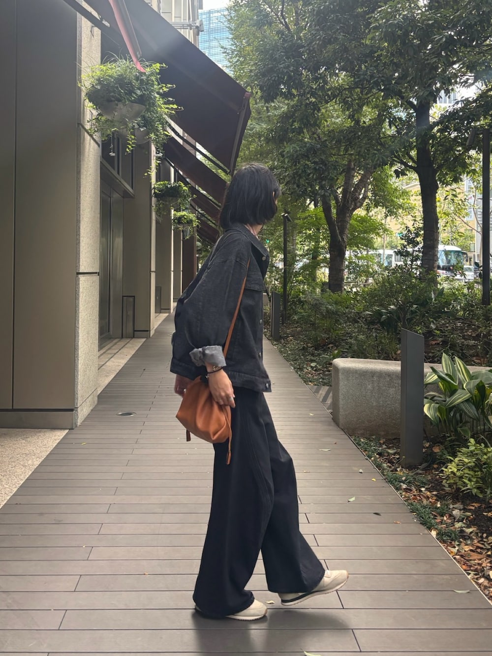ブラック系のデニムジャケット、ブラック系のデニムパンツ、ベージュ系のスニーカーを着用したメンズの秋コーディネートの2枚目の写真