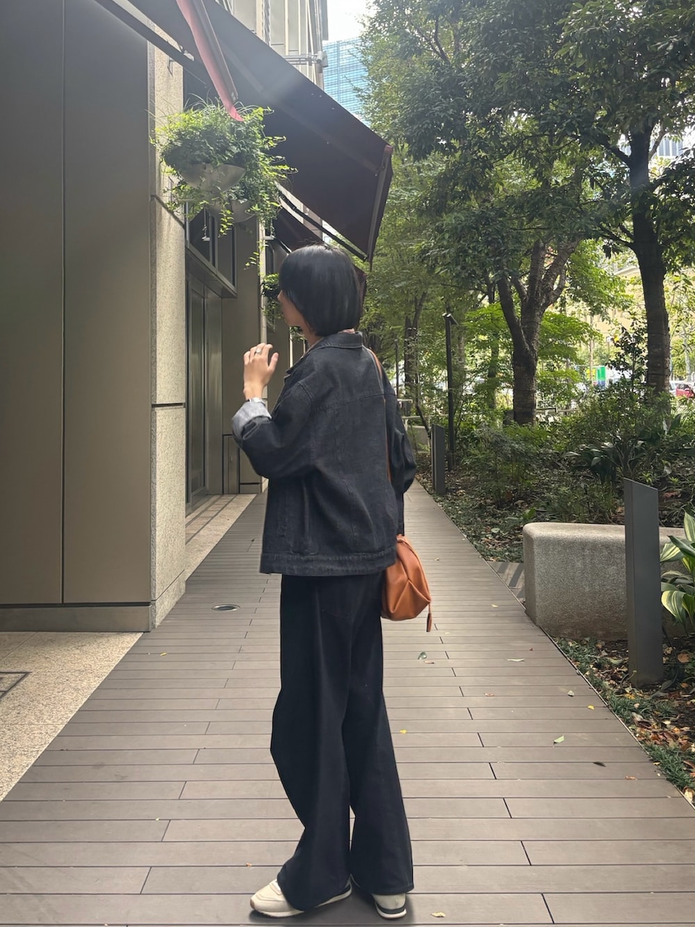 ブラック系のデニムジャケット、ブラック系のデニムパンツ、ベージュ系のスニーカーを着用したメンズの秋コーディネートの3枚目の写真
