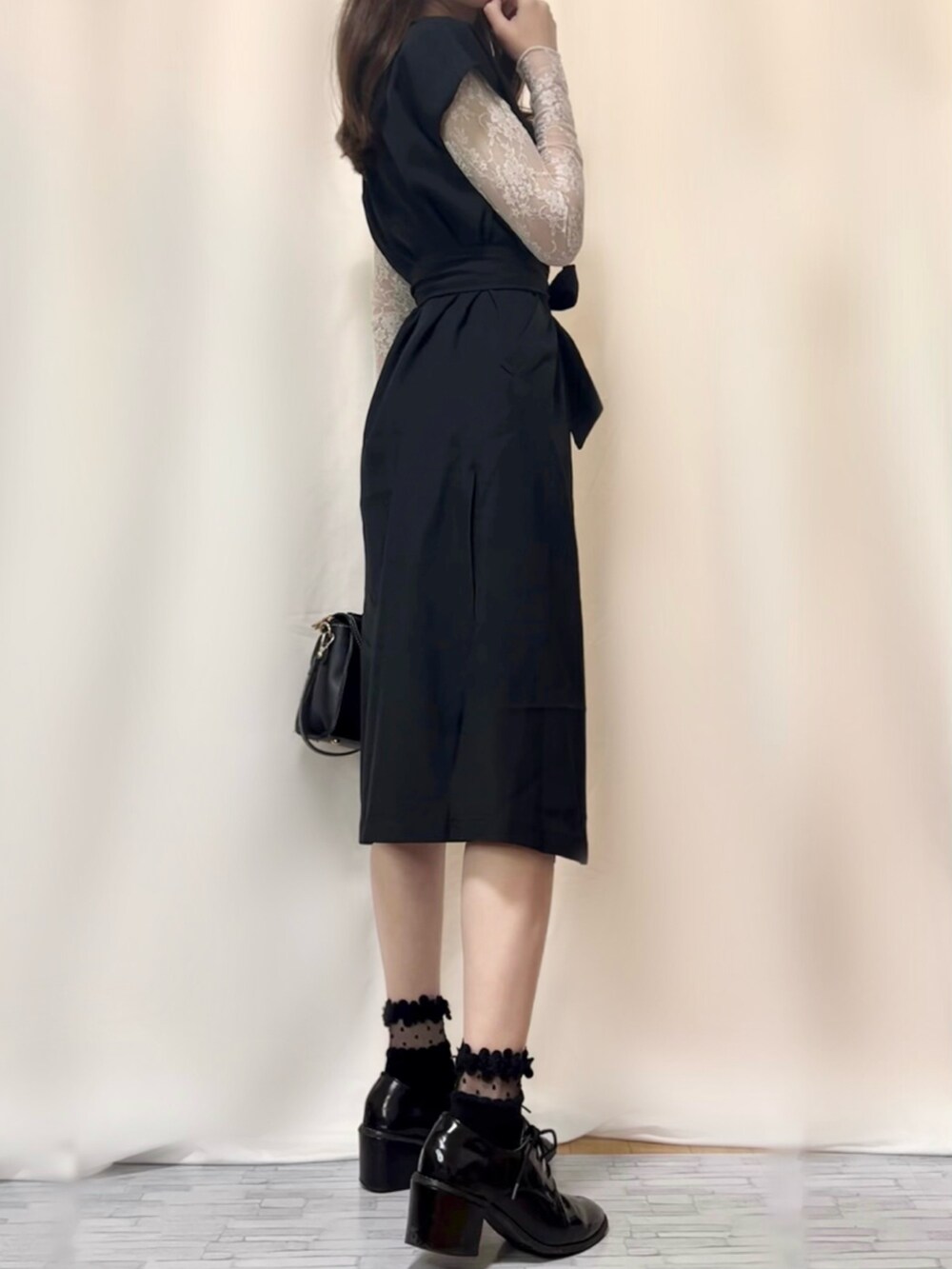 ブラック系のワンピース、ブラック系のその他パンツ、ブルー系のショルダーバッグを着用したレディースの春コーディネートの4枚目の写真