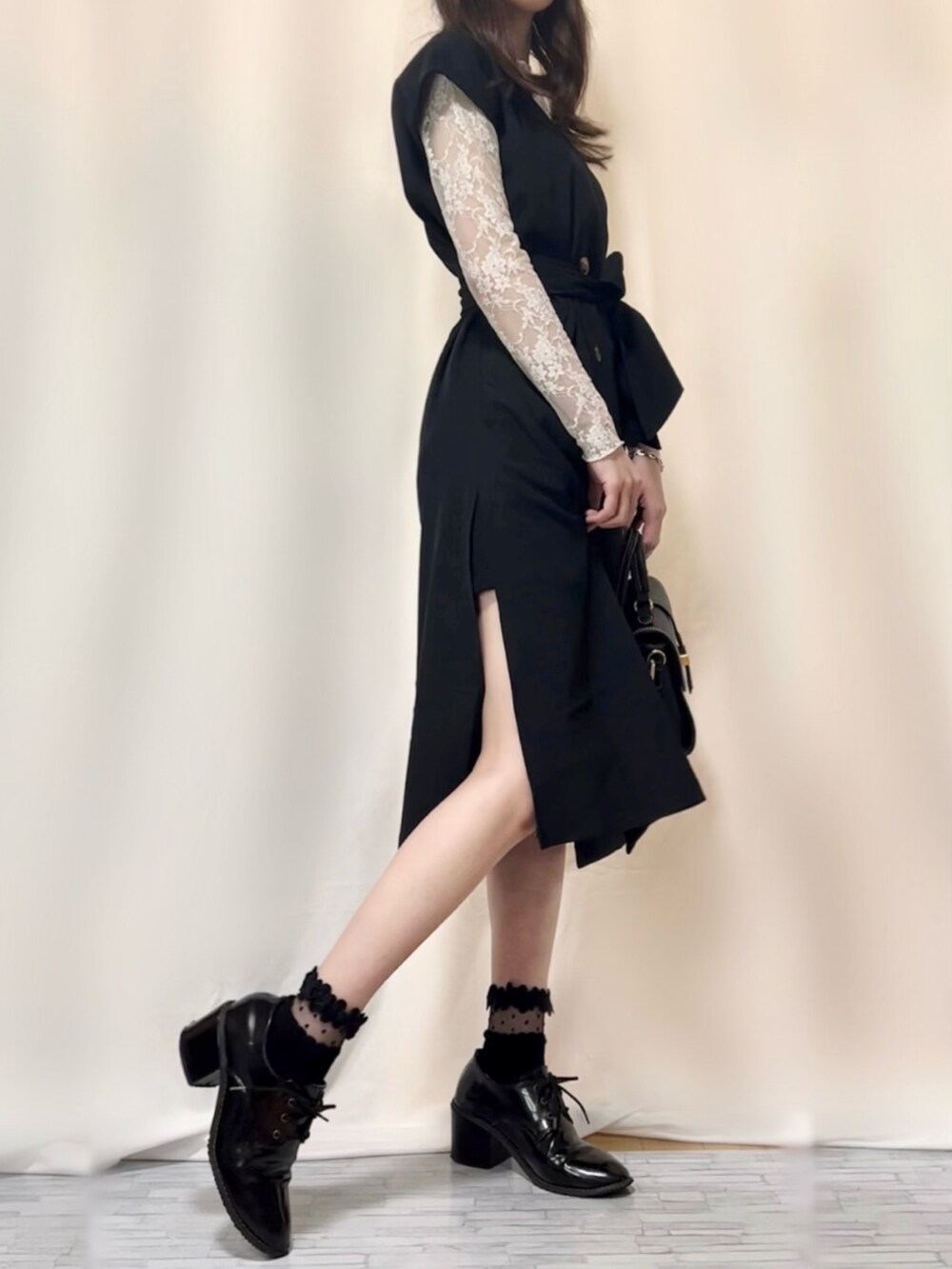 ブラック系のワンピース、ブラック系のその他パンツ、ブルー系のショルダーバッグを着用したレディースの春コーディネートの3枚目の写真