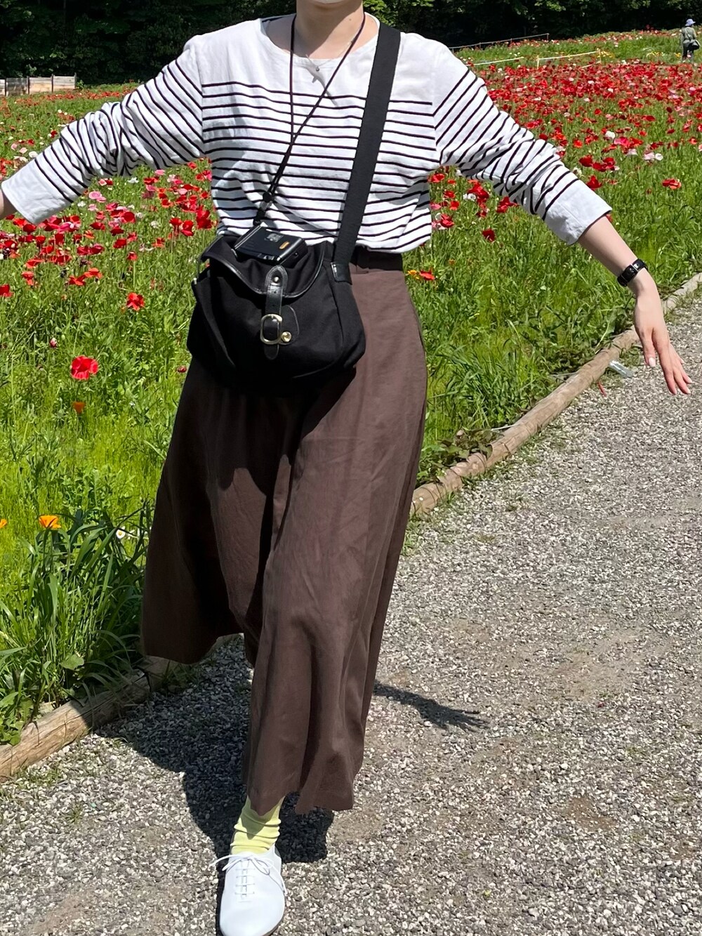 ホワイト系のTシャツ/カットソー、ブラウン系のスカート、ホワイト系のドレスシューズを着用したレディースの春コーディネートの2枚目の写真