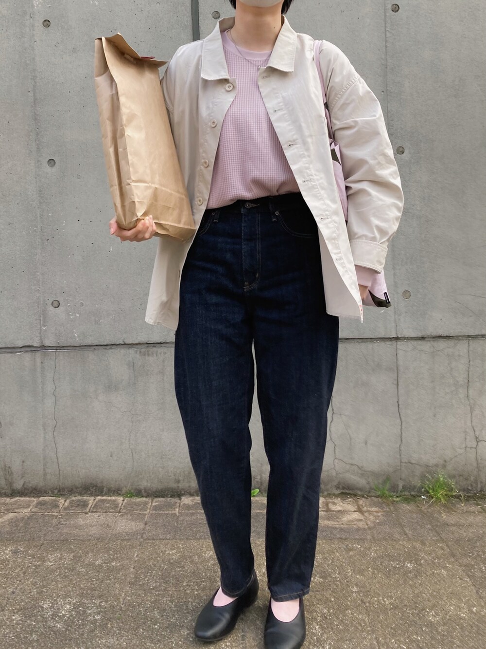 ピンク系のトートバッグ、ホワイト系のシャツ/ブラウス、ブルー系のデニムパンツを着用したレディースの春コーディネートの2枚目の写真