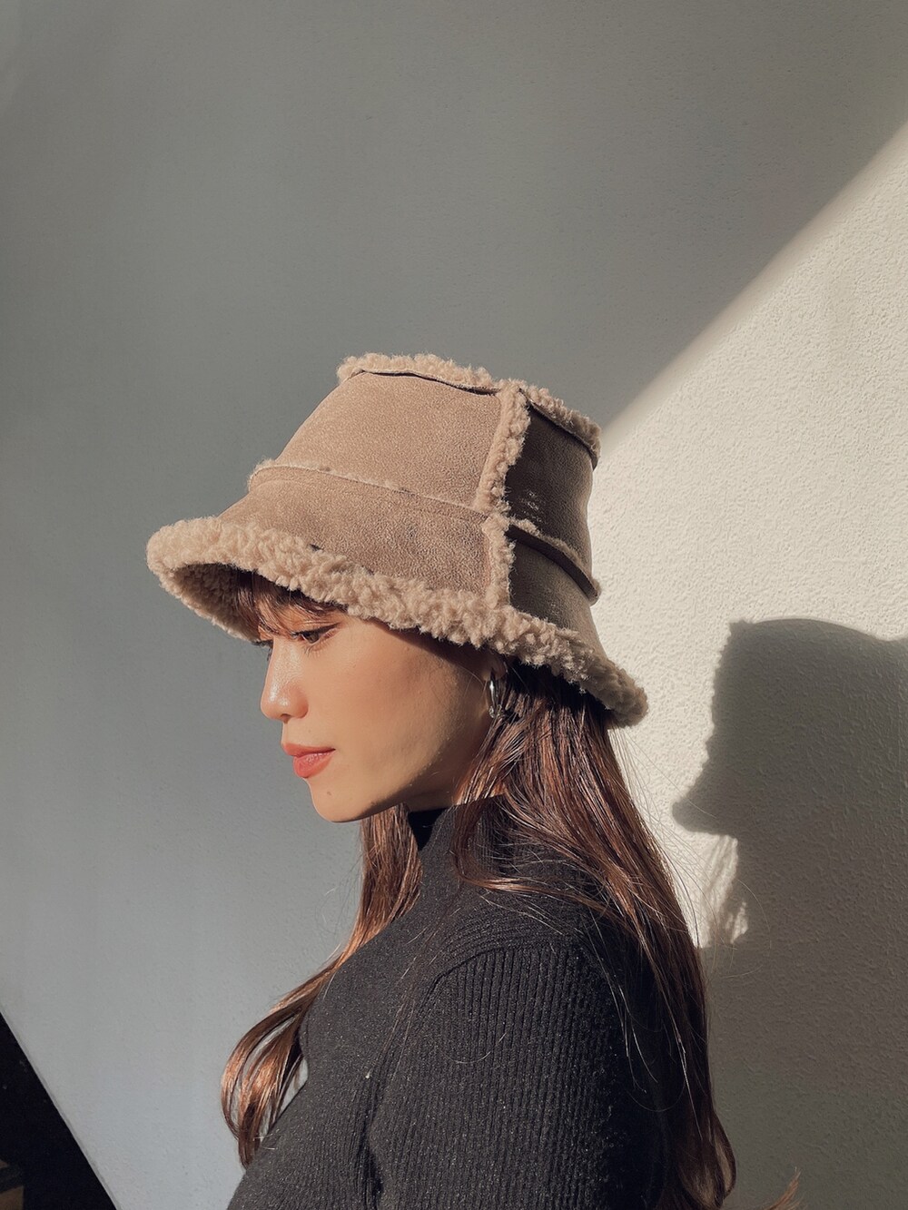 ブラック系のニット/セーター、ベージュ系のハットを着用したレディースの秋コーディネートの2枚目の写真