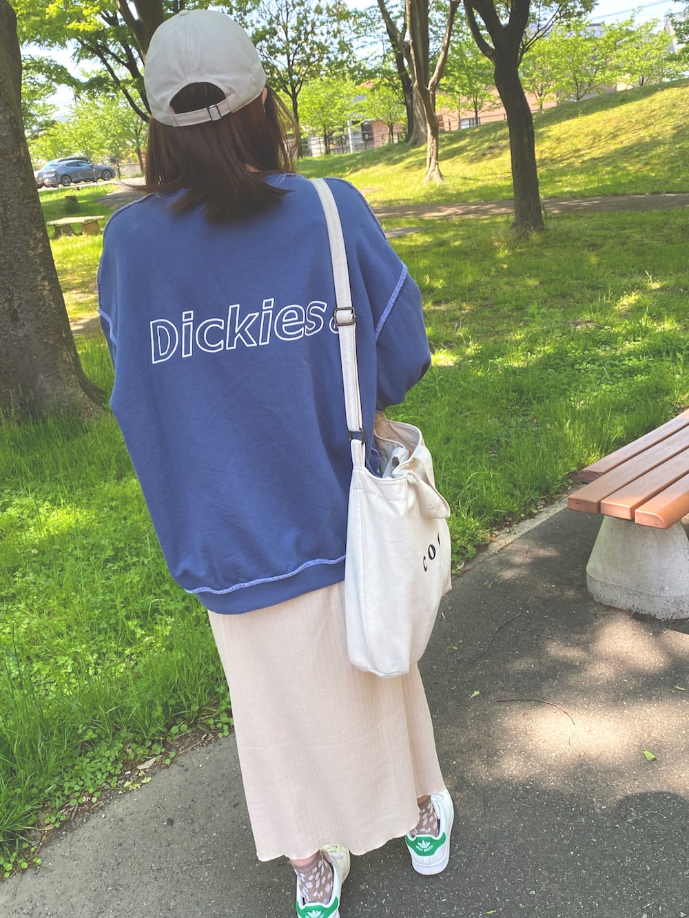 ブルー系のスウェット、ベージュ系のスカート、ホワイト系のトートバッグを着用したレディースの春コーディネートの2枚目の写真